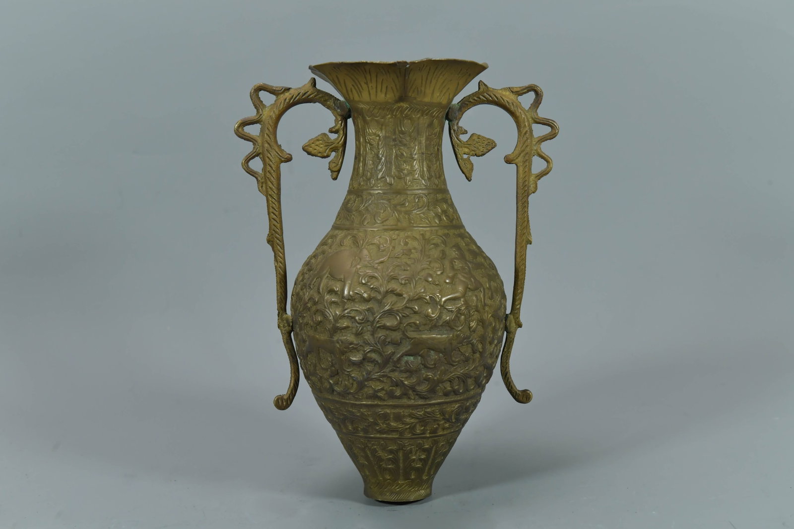 Antique Orient Hand Engraved Brass Relief Urn Vase w/Double Handles: Antique Orient Hand Engraved Brass Relief Urn Vase w/Double Handles, Drilled. 9"1/2Tall, 4"1/2 Body wide; It's overall in good condition except the top edge of the vase is slightly chipped.
