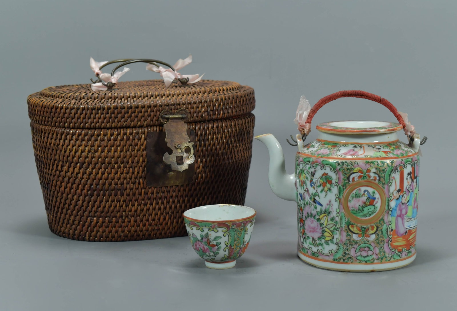 Antique Chinese Famille Rose Porcelain Tea Set in Wicker Basket: Antique Chinese Famille Rose Porcelain Tea Set in Wicker Basket. Teapot with lid 5"Tall and 4"3/4body wide; Cup 2"3/4W x 2"W; Basket 10"L x 7"1/2W x 6"H; Overall in good condition.