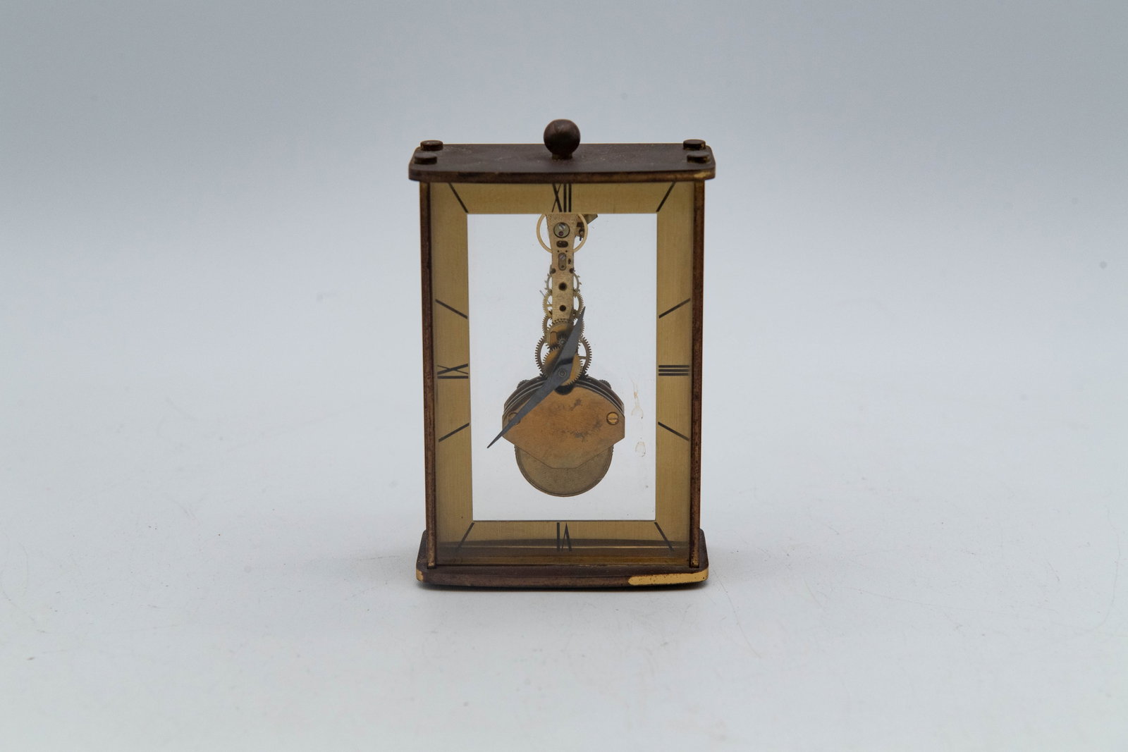 Vintage Brass Desk Shelf Skeleton Clock, West Germany: Vintage Brass Desk Shelf Skeleton Clock, West Germany. Measures 3" x 4" x 1"1/2. Overall in good vintage condition, the brass case shows age-related tarnishing and patina; The movement has not been te