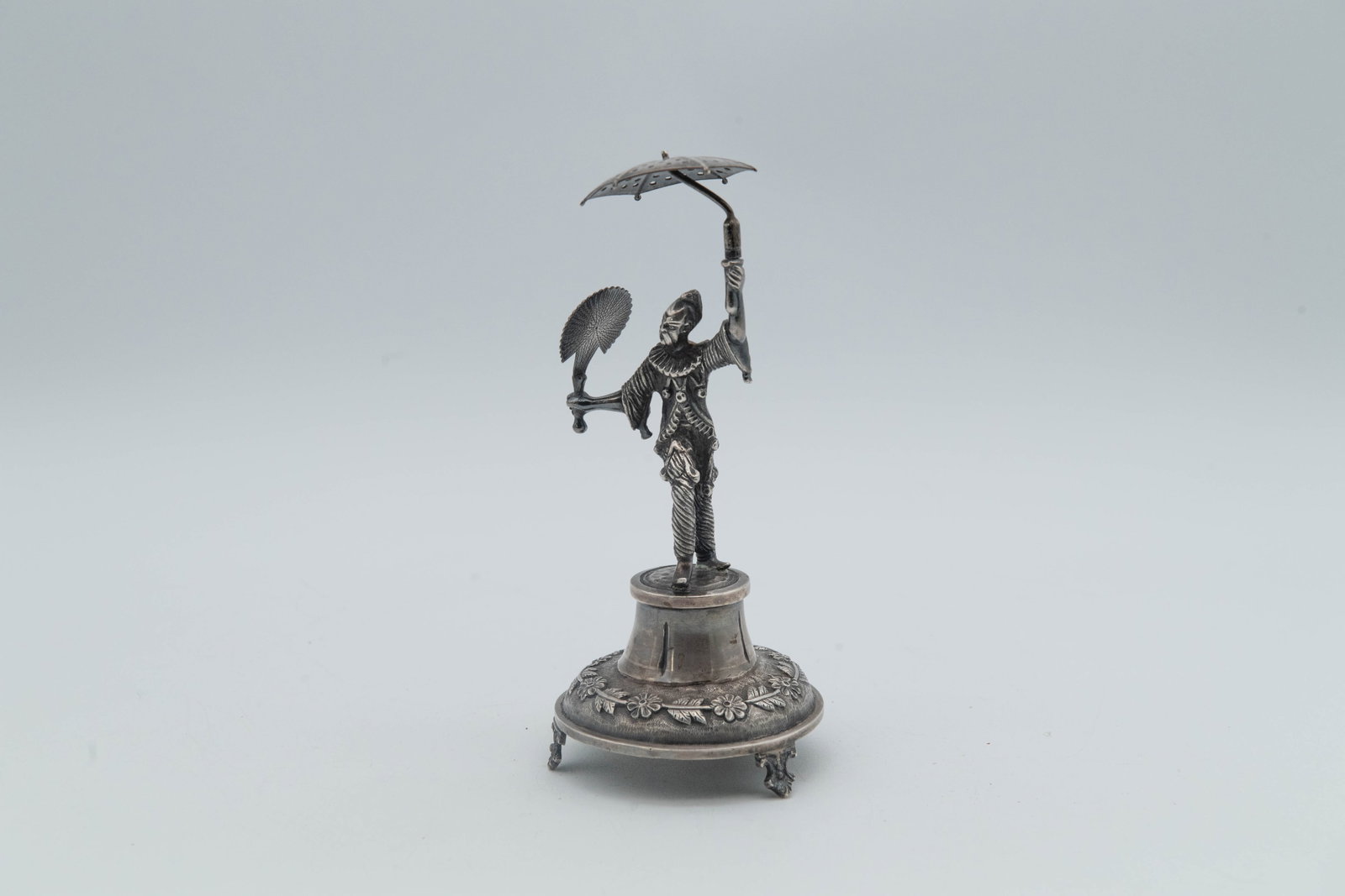 Vintage Silver Pierrot Clown Figurine Statue w/Marks PRATA J.R: Vintage Silver Pierrot Clown Figurine Statue W/Marks PRATA J.R. This figurine statue holding a polka-dot umbrella and a fan, and it is mounted on a pedestal base decorated with a floral motif. Measure