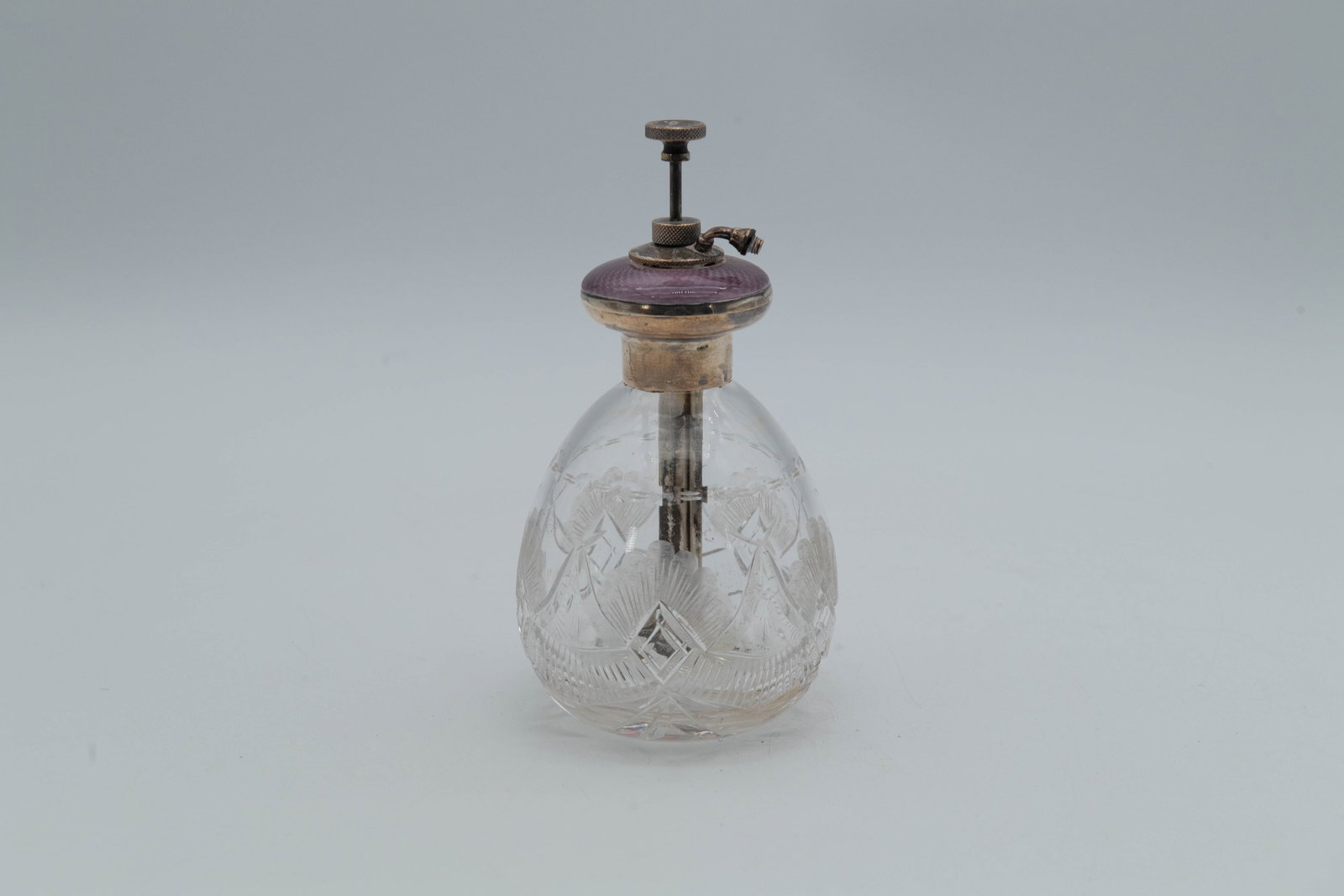 Vintage Vanity Perfume Bottle w/Purple Guilloche Enamel & Sterling Silver Casings: Vintage Vanity Ornate Cut Crystal Glass Scent Perfume Bottle w/Purple Guilloche Enamel & Marked Sterling Silver Casings. Measures approx. 5"H x 3"1/2W, Overall in good vintage condition, the enamel ha