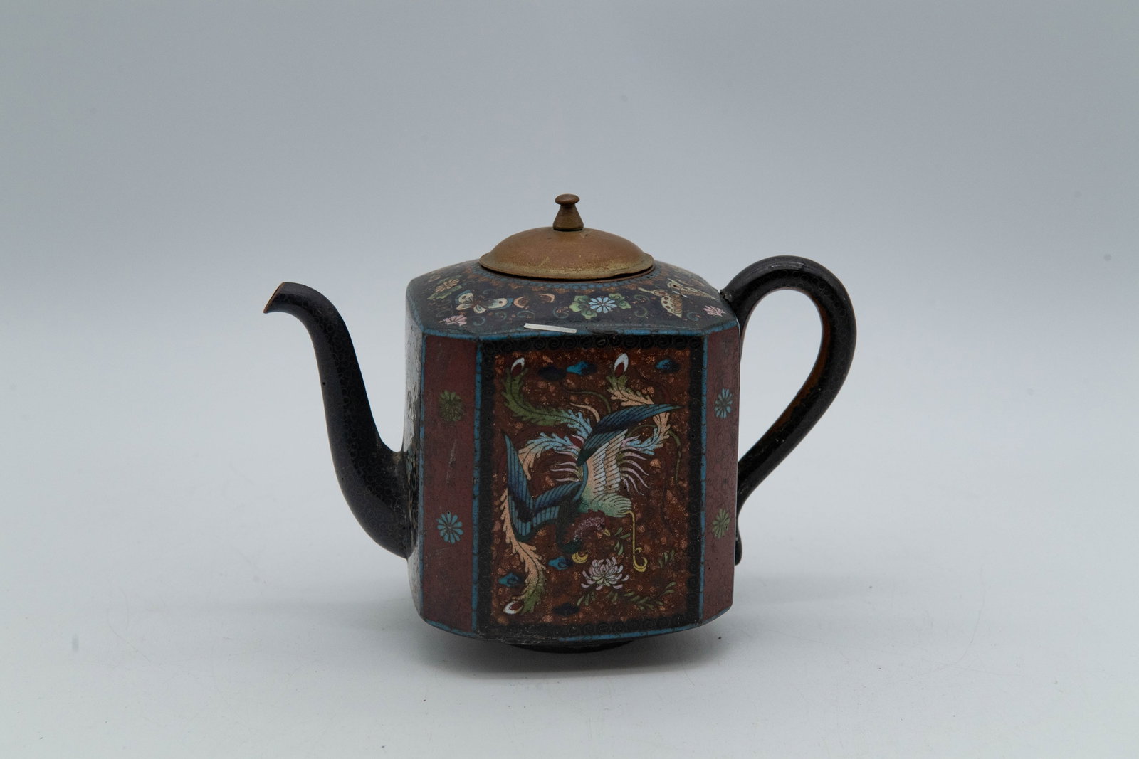 Vintage/Antique Asian Dark Cloisonne Enamel Octagon Teapot w/Phoenix & Butterfly Motif: Vintage/Antique Asian Dark Cloisonne Enamel Octagon Teapot w/Phoenix & Butterfly Motif. Overall in good antique condition. The decorative motifs on the body are well preserved. There is a small chip t