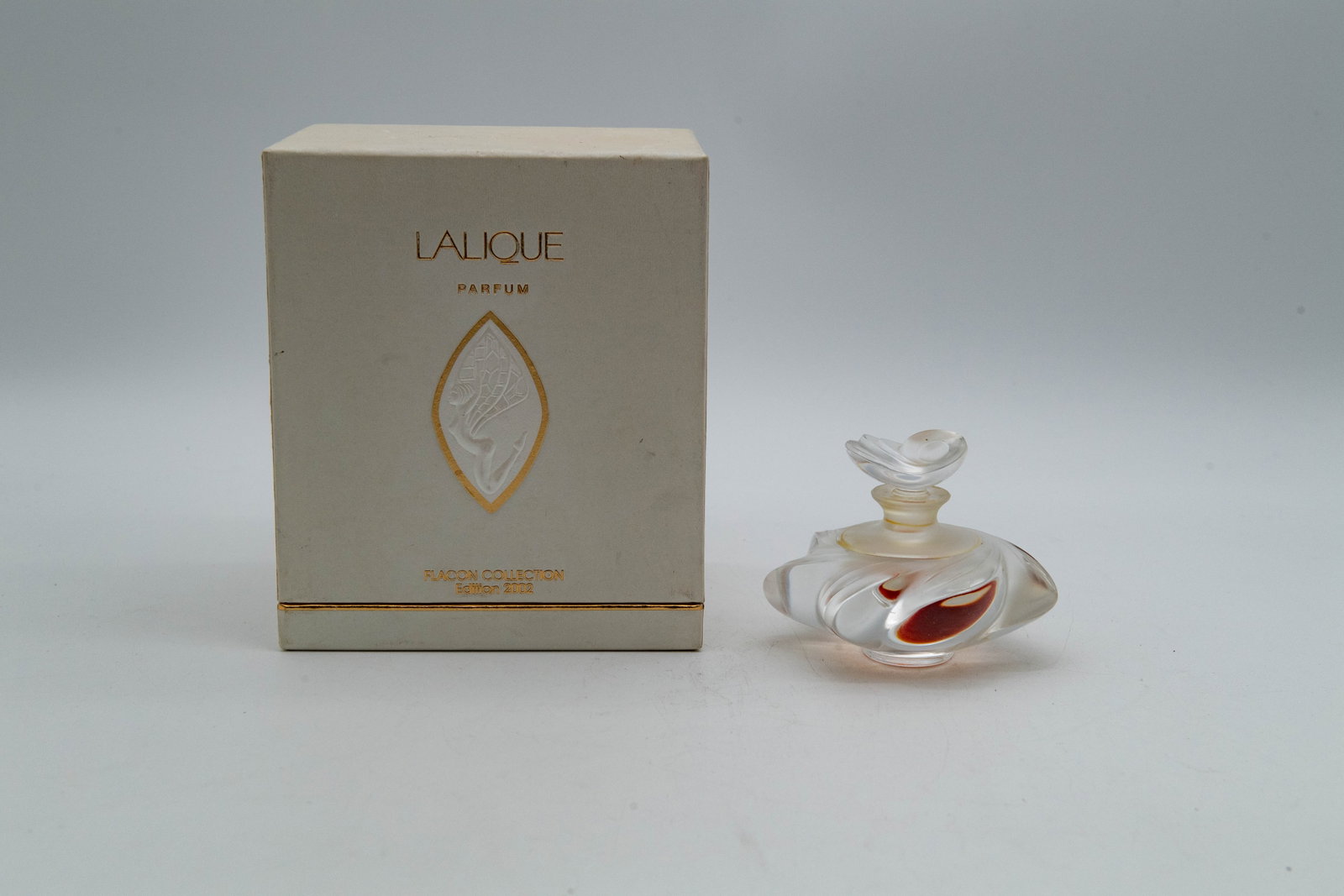 Vintage Clear & Frosted Crystal Perfume Bottle w/Etched "Lalique France": Vintage Clear & Frosted Crystal Perfume Bottle w/Etched "Lalique France" w/Box. Measures approx. 4"W x 3"H. Overall in good condition with minor wear to the base. Contains a small amount of remaining 