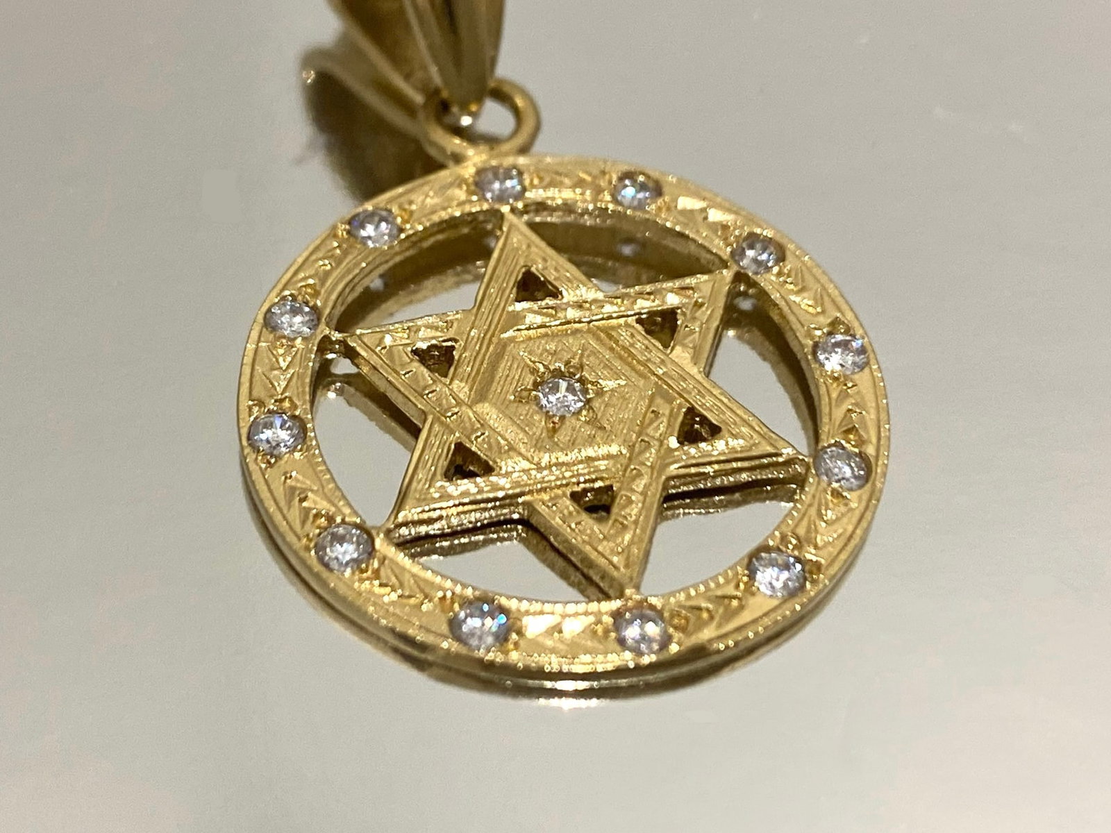 18k Yellow Gold and Diamond Star of David in Circle Pendant, Weight: 8.2 Grams: This exquisite pendant features a stunning Star of David encircled and adorned with 13 sparkling diamonds. Crafted in 18K yellow gold, it is a timeless piece perfect for any occasion.Condition: Like N