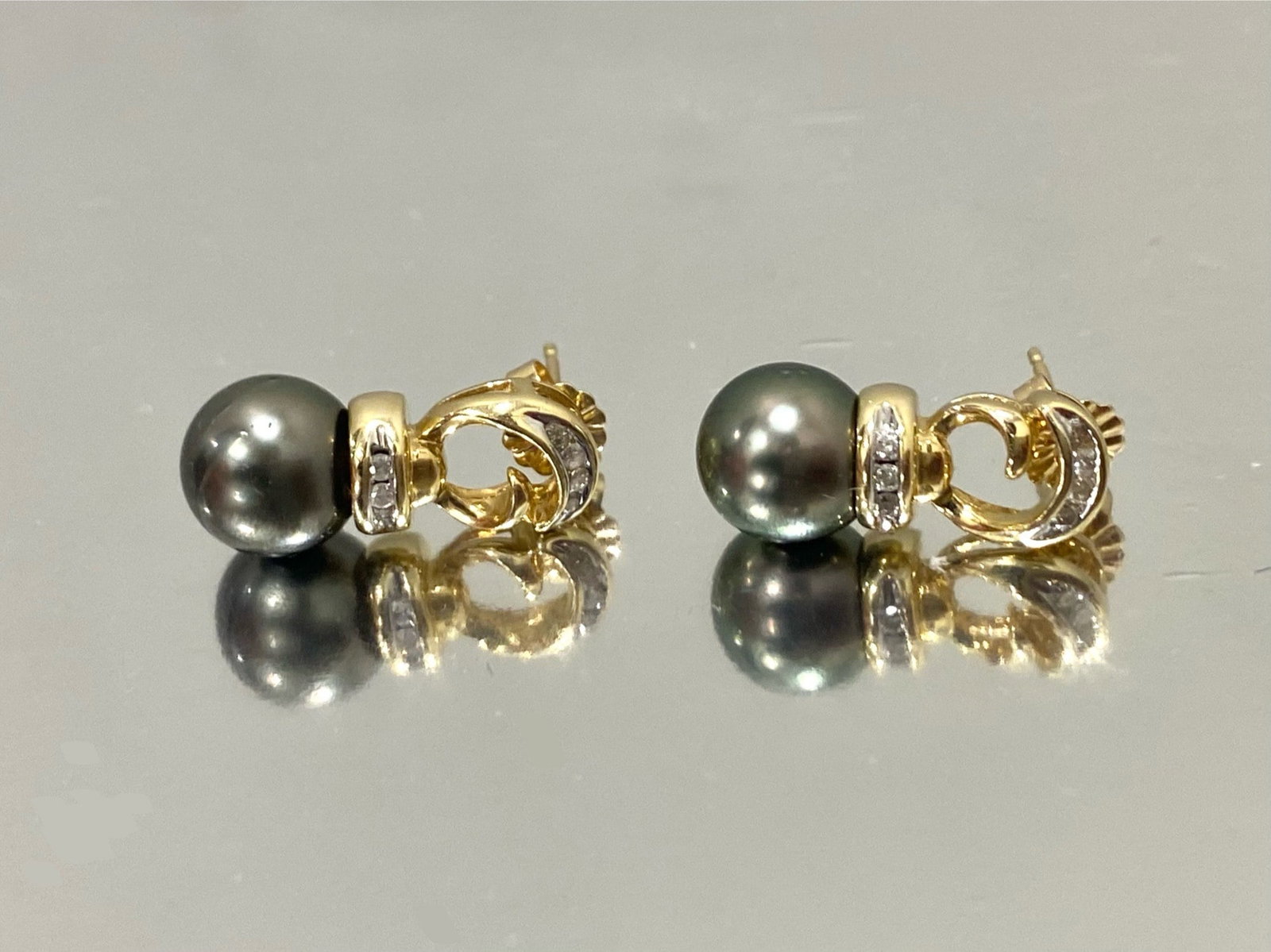 Elegant Tahitian Cultured Pearl Diamond Earrings in 14k Yellow gold: Illuminate your look with these exquisite earrings crafted in 14K yellow gold. Adorned with Tahitian cultured pearls measuring 9mm in diameter, they exude timeless elegance. Surrounding each pearl are