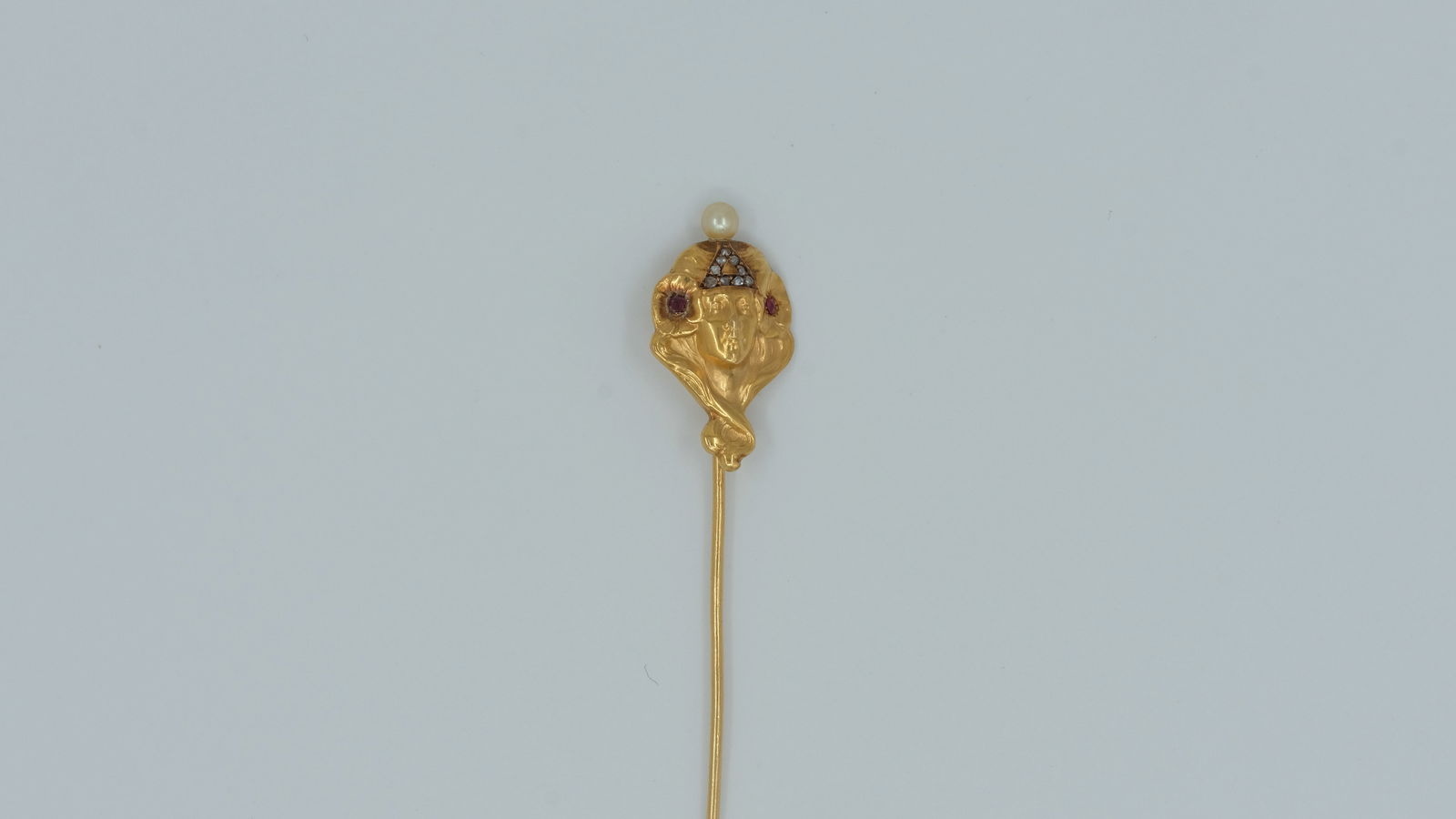 An 18 ct gold, diamond and pearl art nouveau tie-pin: An 18 ct gold , diamond and pearl art nouveau tie-pin In the style of Alphonse Mucha 7 cm long weight 2.9 g