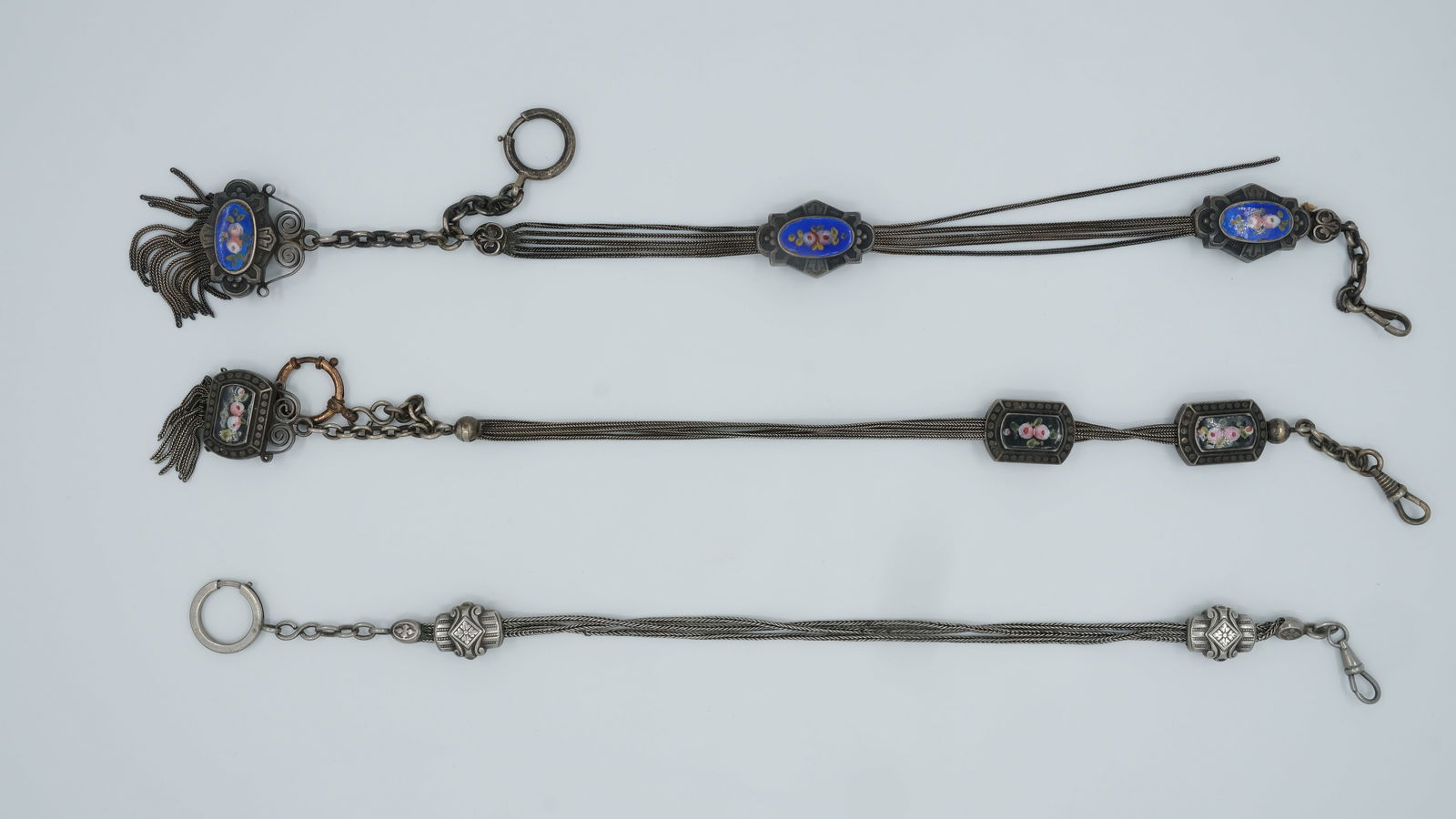 A lot of two Antique Silver and enamel pocketwatch chatelaine.: A lot of two Antique Silver and enamel pocketwatch chatelaine's. 19th century. Weight: 109 gr. Condition: Small replacement unoriginal parts, minor chips at the enamel, otherwise in good and fair