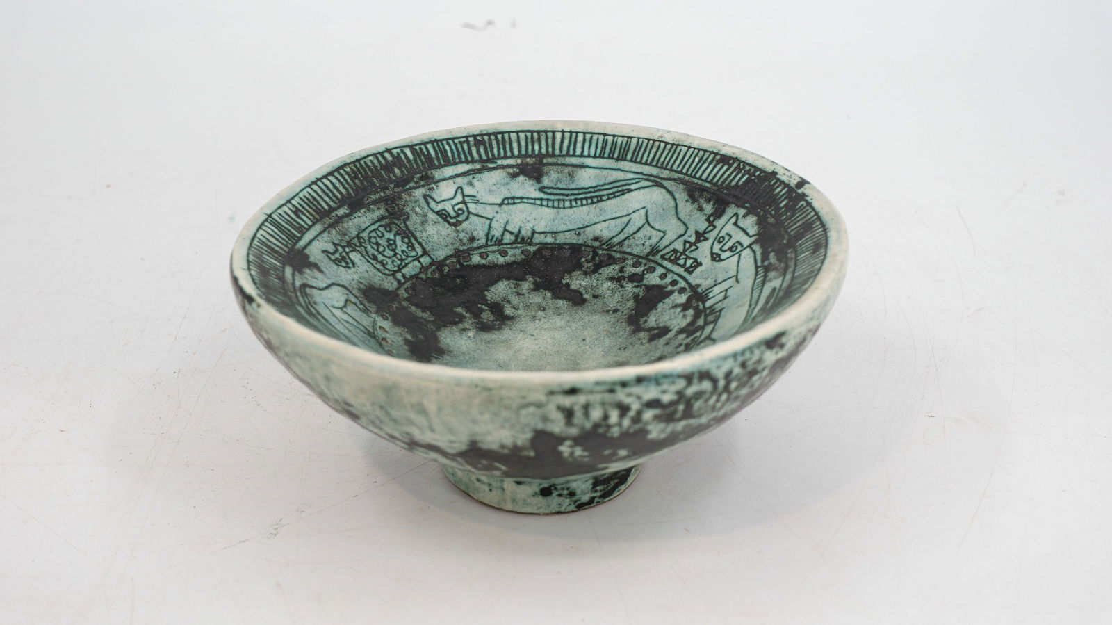 A french glazed ceramic footed bowl by Jacques Blin (1920-1995).: A french glazed ceramic footed bowl by Jacques Blin (1920-1995). Decorated with Art shaped Cats. W: 22.5 cm. Circa 1950's.