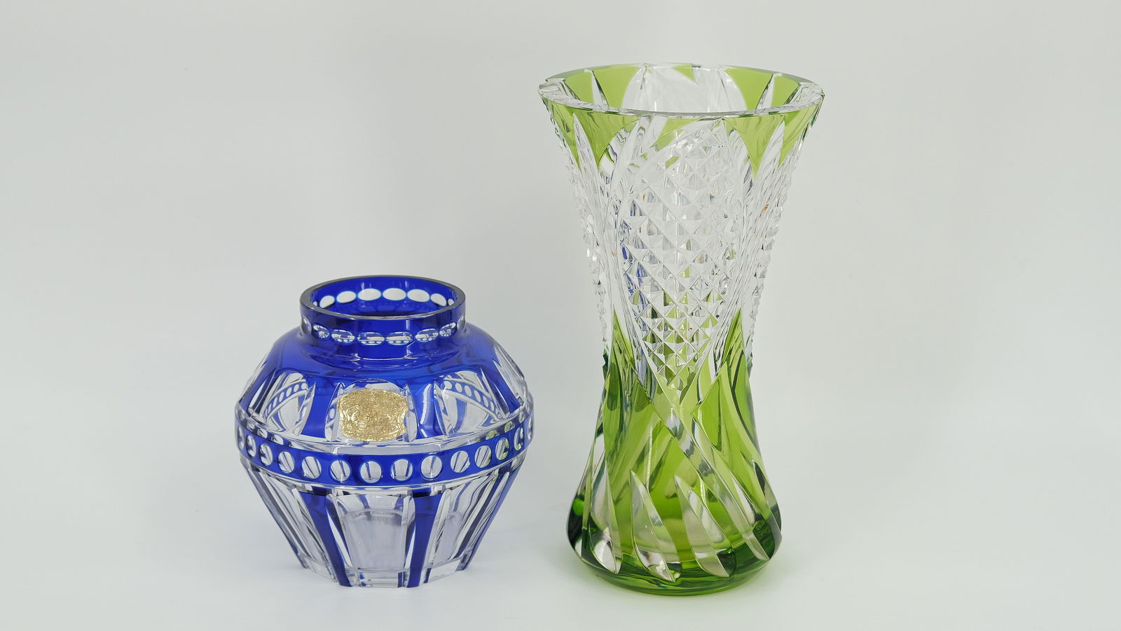 A lot of two crystal Val Saint-Lambert vases. A blue and a green spiralling vase, both with a label.: A lot of two crystal Val Saint-Lambert vases. One smaller blue vase and a green spiralling vase both with a label. Late 20th Century. Height: 15cm - 25cm