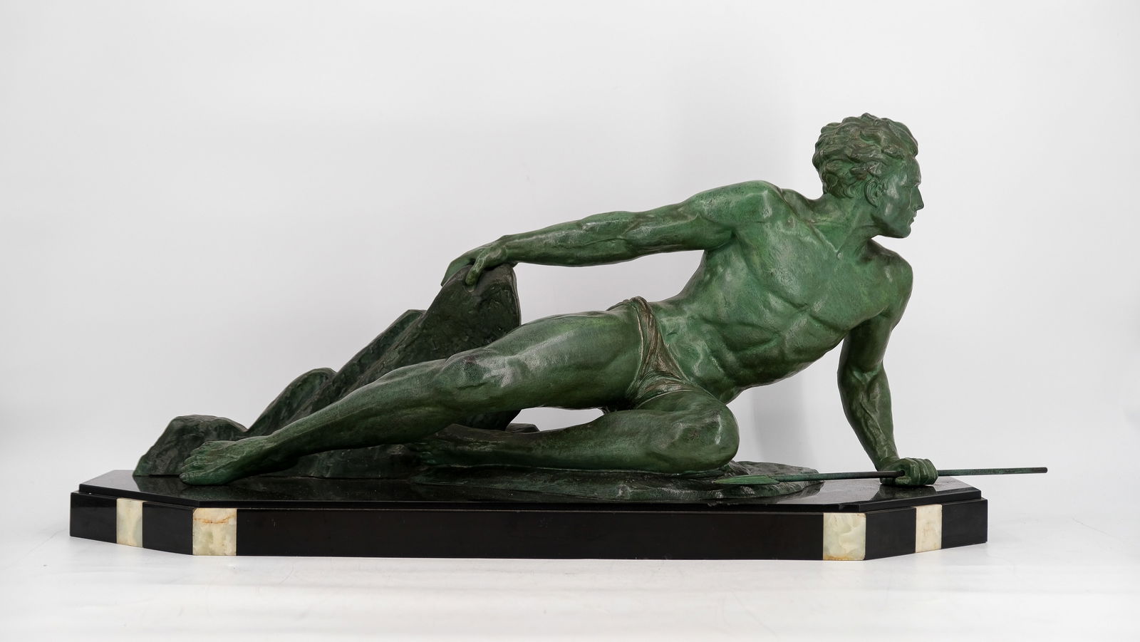 An Art deco green patinated figural spelter sculpture of a "Spear thrower", by Jean de Roncourt.: An Art deco green patinated figural spelter sculpture of a "Spear thrower", modelled by Jean de Roncourt (1869-1937) France, 1930's. W: 72 cm (without spear) H: 32 cm