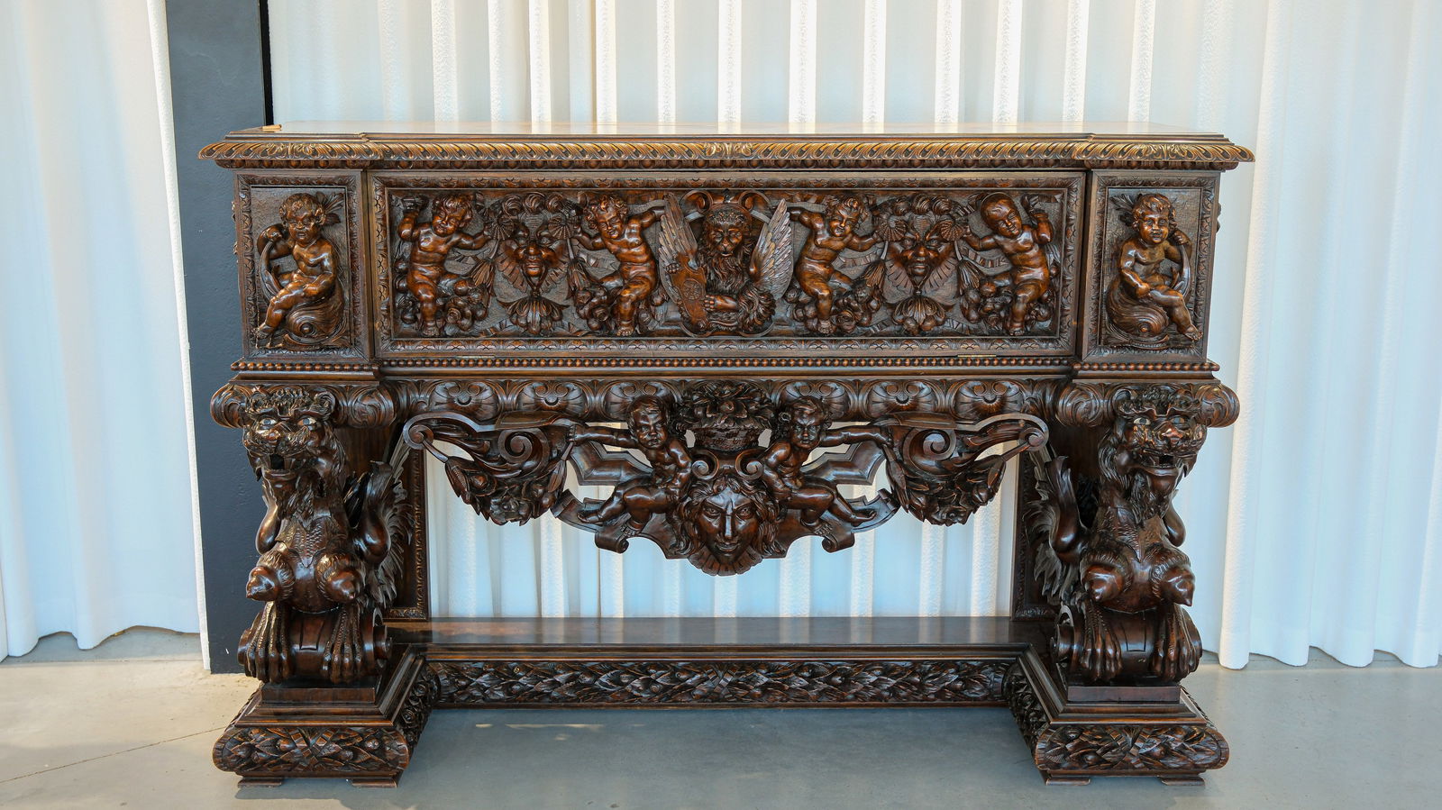 An Italian Antique imposing baroque and richly carved oak cassone chest on stand: An Italian Antique imposing baroque and richly carved oak cassone chest on stand, figural decorated with putti and winged dragon sculptures. Italy, 19th Century. W: 157,5 cm - H: 132 cm - D: 74 cm