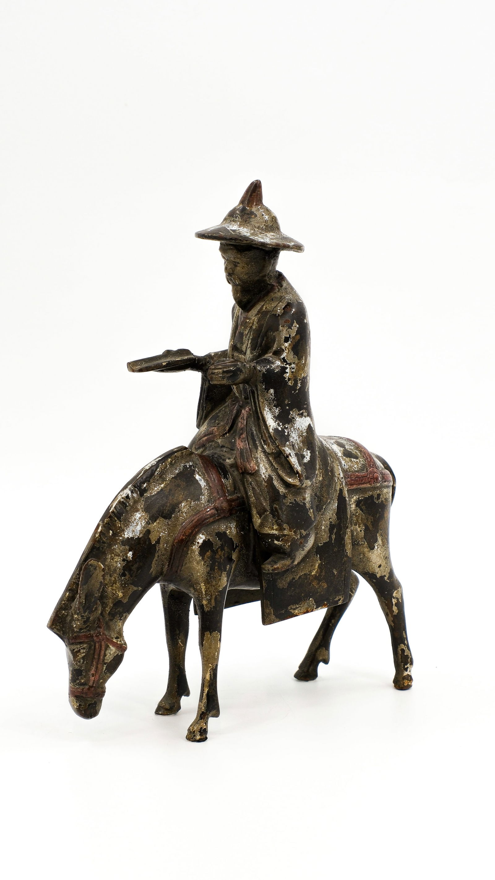 An Oriental patinated bronze sculpture of a man on a donkey