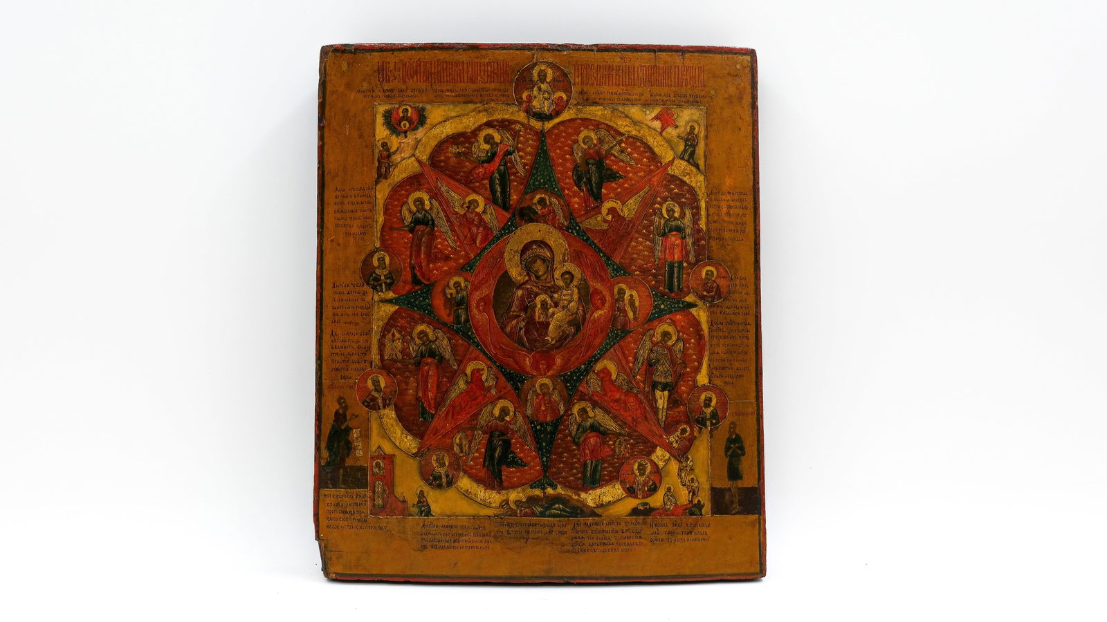 An antique Russian tempera on wood icon Theotokos in the Burning Bush with surrounding angels: An antique Russian tempera on wood icon depicting the Mother of God with Child in the center of a burning bush mandorla, surrounded by angels, prophets, and various saints, with extensive inscriptions