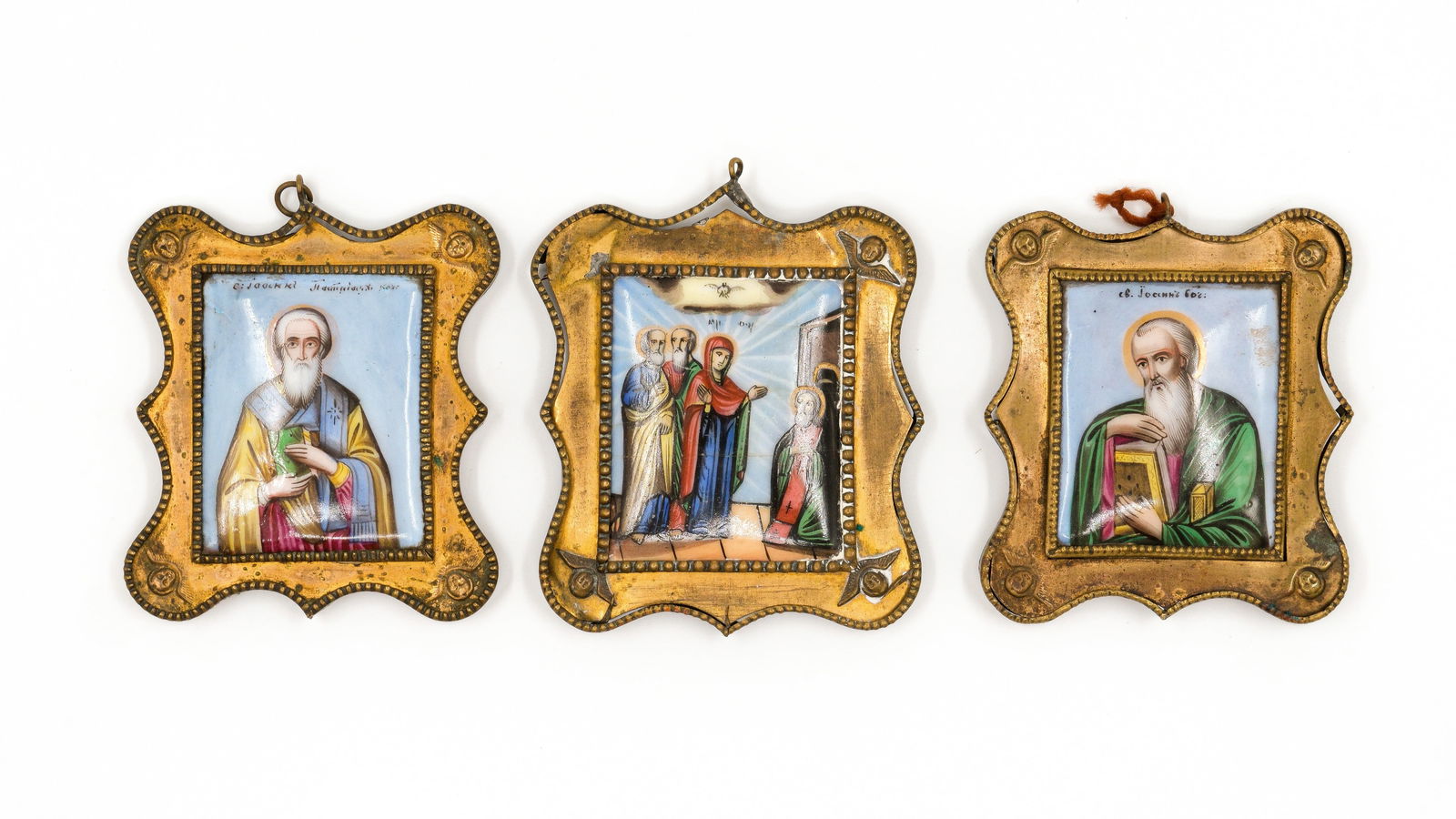 A lot of three Russian gilt brass and enamel miniatures with saints and a biblical scene: A lot of three antique Russian decorated enamel and gilt brass miniatures plaques, depicting saints and a biblical scene, each mounted in an ornate gilt shaped frame with beaded borders and suspension