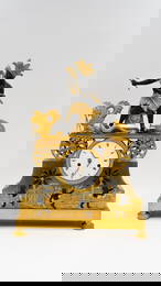 An important antique French Directoire fire-gilded bronze decorated mantel clock “American