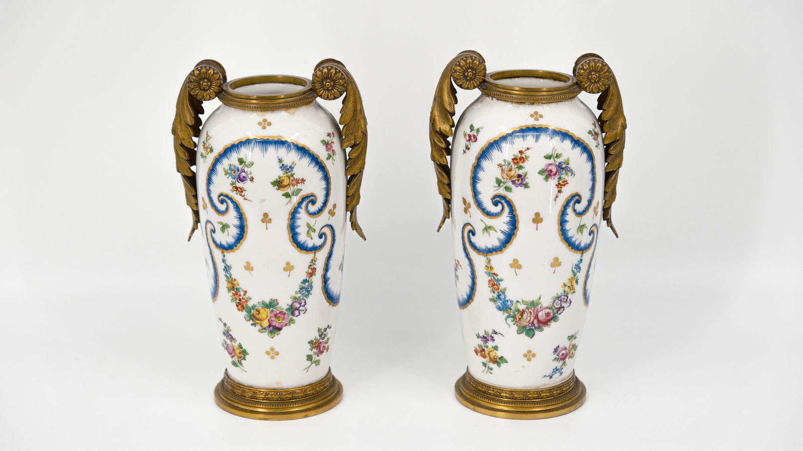 A set of two French antique gilt bronze mounted decorated porcelain vases: A set of two French antique gilt bronze mounted decorated porcelain vases. Bottom with a Sèvres style mark. Circa 1900. H: 20 cm