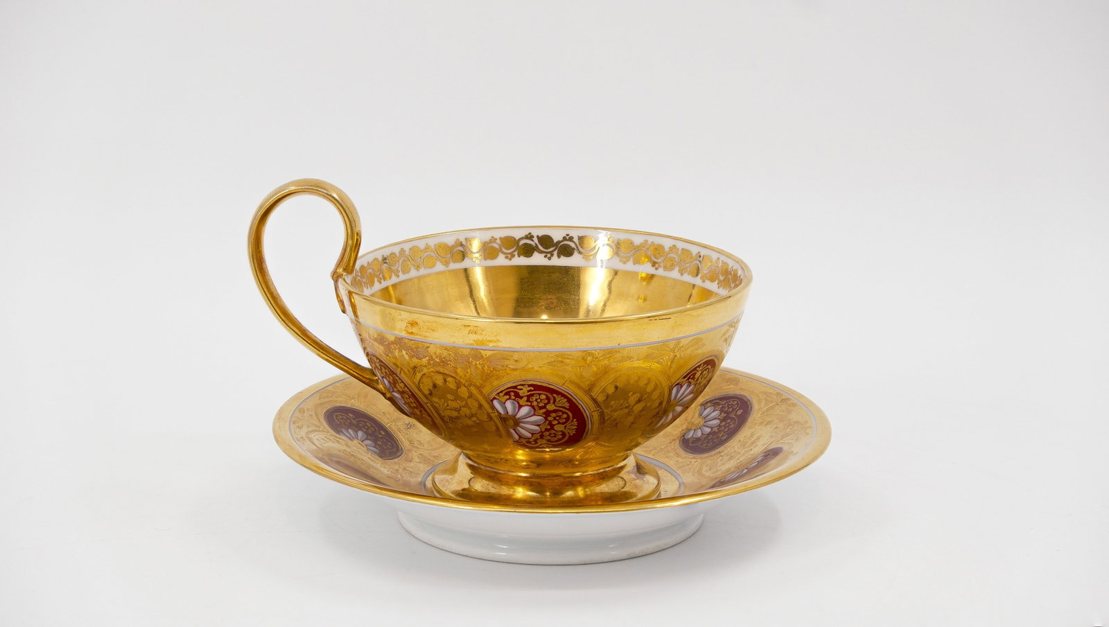 A large French Paris glazed porcelain cup and underplate by SCHOELCHER: A large French Paris glazed porcelain cup and underplate by SCHOELCHER. Hand-painted and richly gilt decorated on a red background. Marked. Circa 1820. W: 6,6 cm, underplate