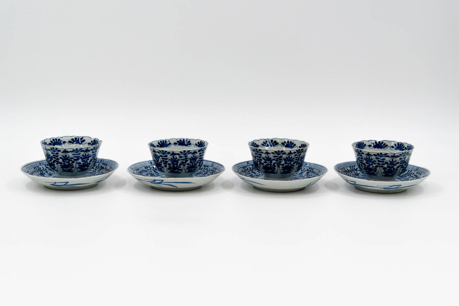 A lot of four Chinese blue and white flora decorated porcelain cups with under plate