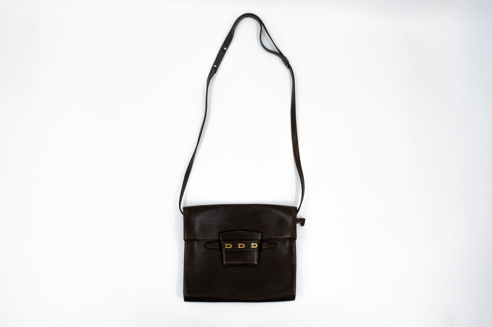 A Delvaux Frimaire crossbody bag in brown leather: A Delvaux Frimaire crossbody bag in brown leather. The strap is adjustable. The interior has one main compartment and a zipper pocket on the side. This bag is in used condition. The interior is ver
