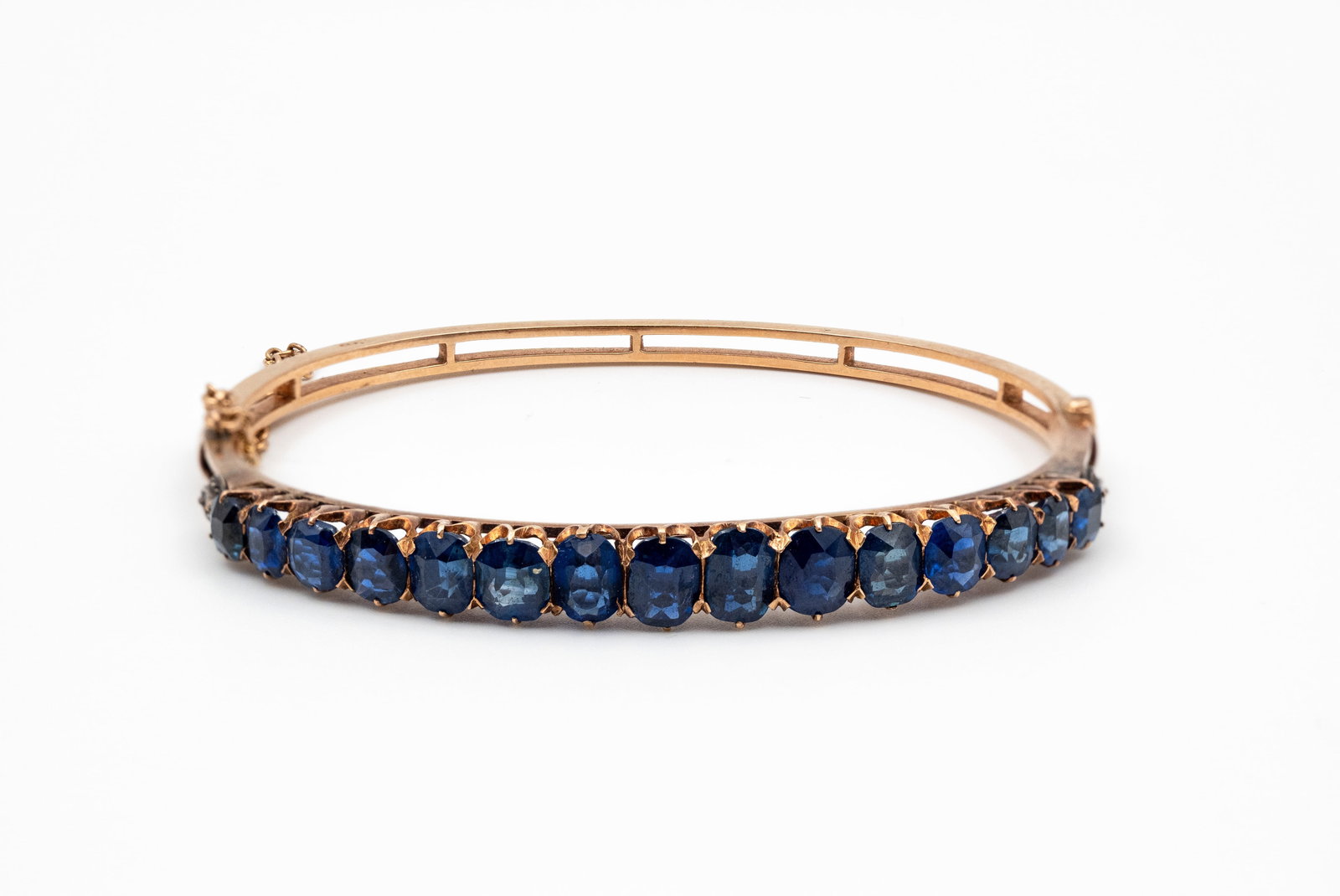 An antique 18 kt gold bangle with a row of oval-cut blue stones in a claw setting (1 of 7)