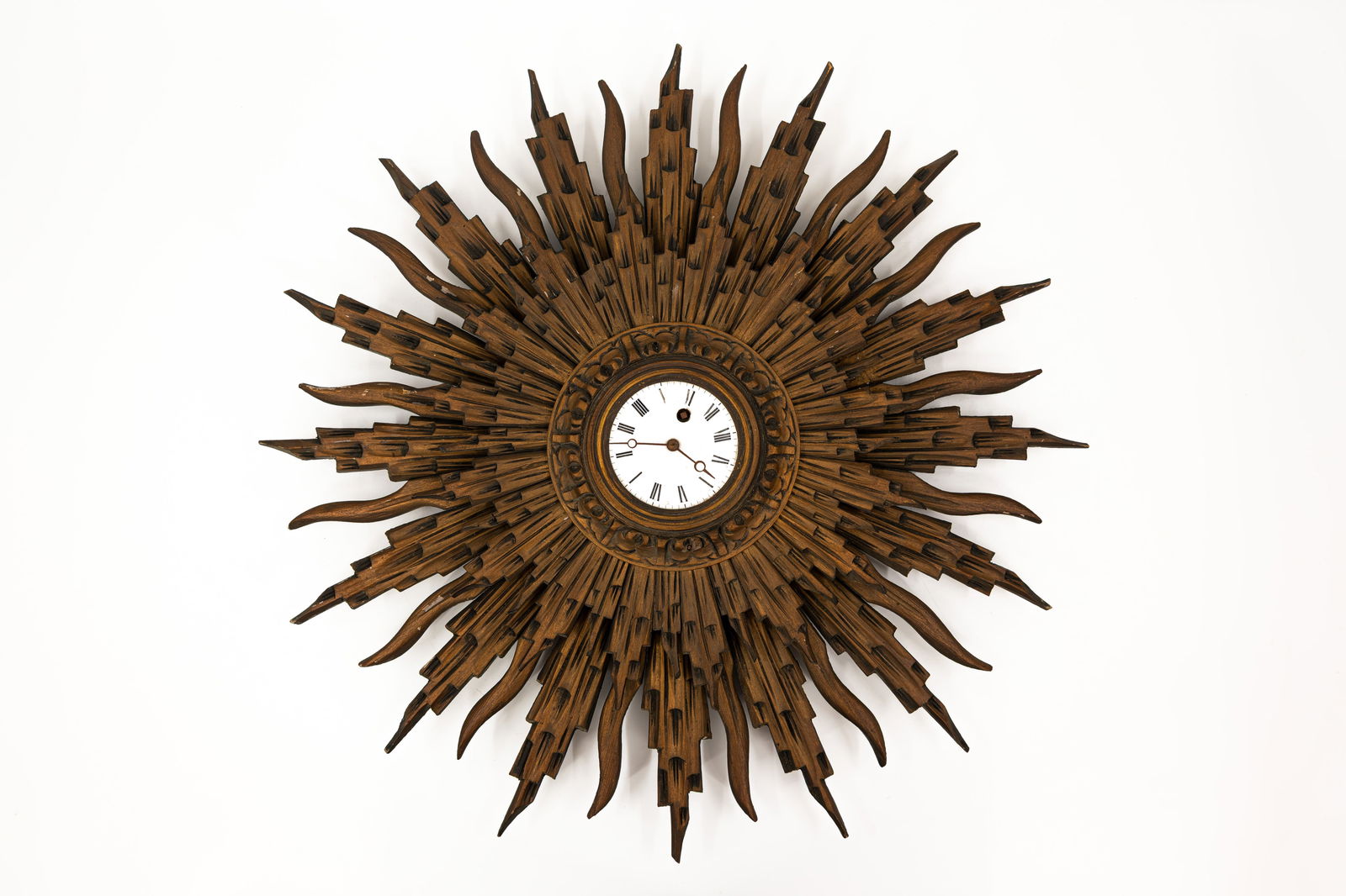 A vintage sun shaped polychrome patinated carved wooden wall clock: A vintage sun shaped polychrome patinated carved wooden wall clock. 20th century. W: 61 cm