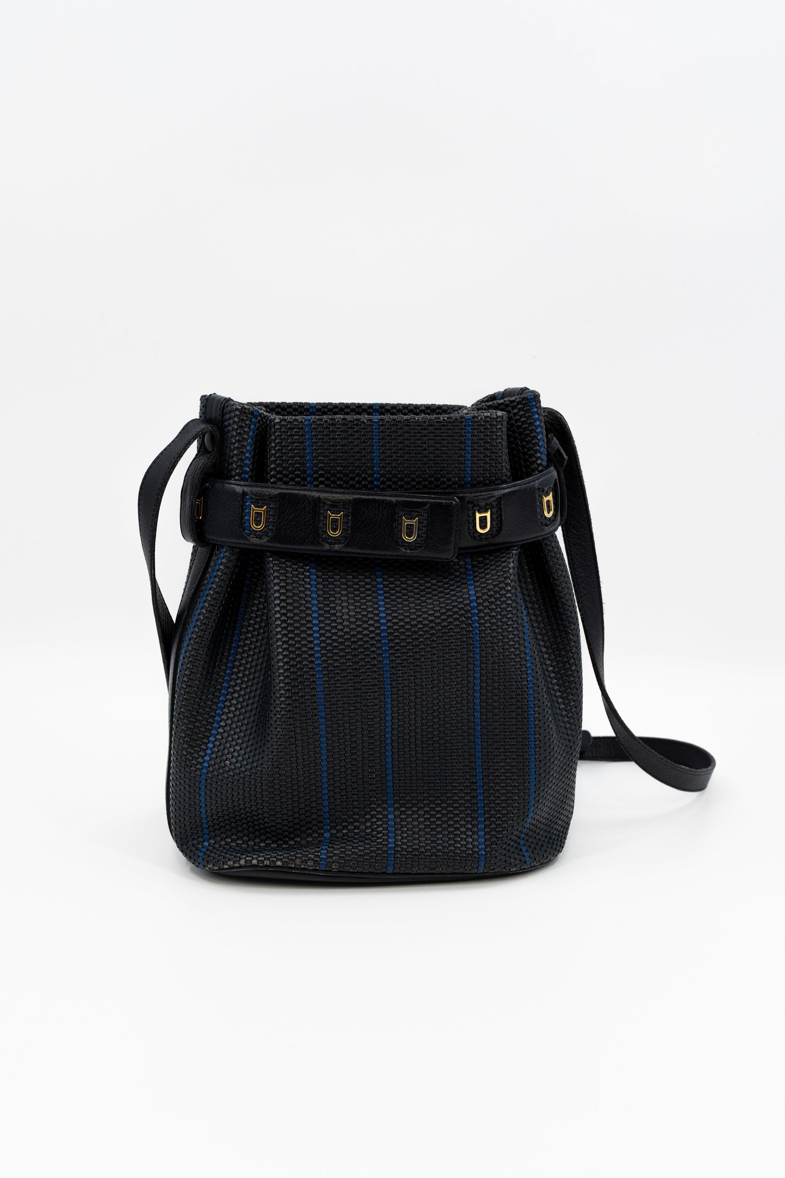 A Delvaux "Calicot" bucket bag in navy toile de cuire: A Delvaux "Calicot" bucket bag in navy toile de cuire with gold toned hardware and adjustable strap, comes with its dustbag. Condition: this bag is in used but neat and well maintained condit