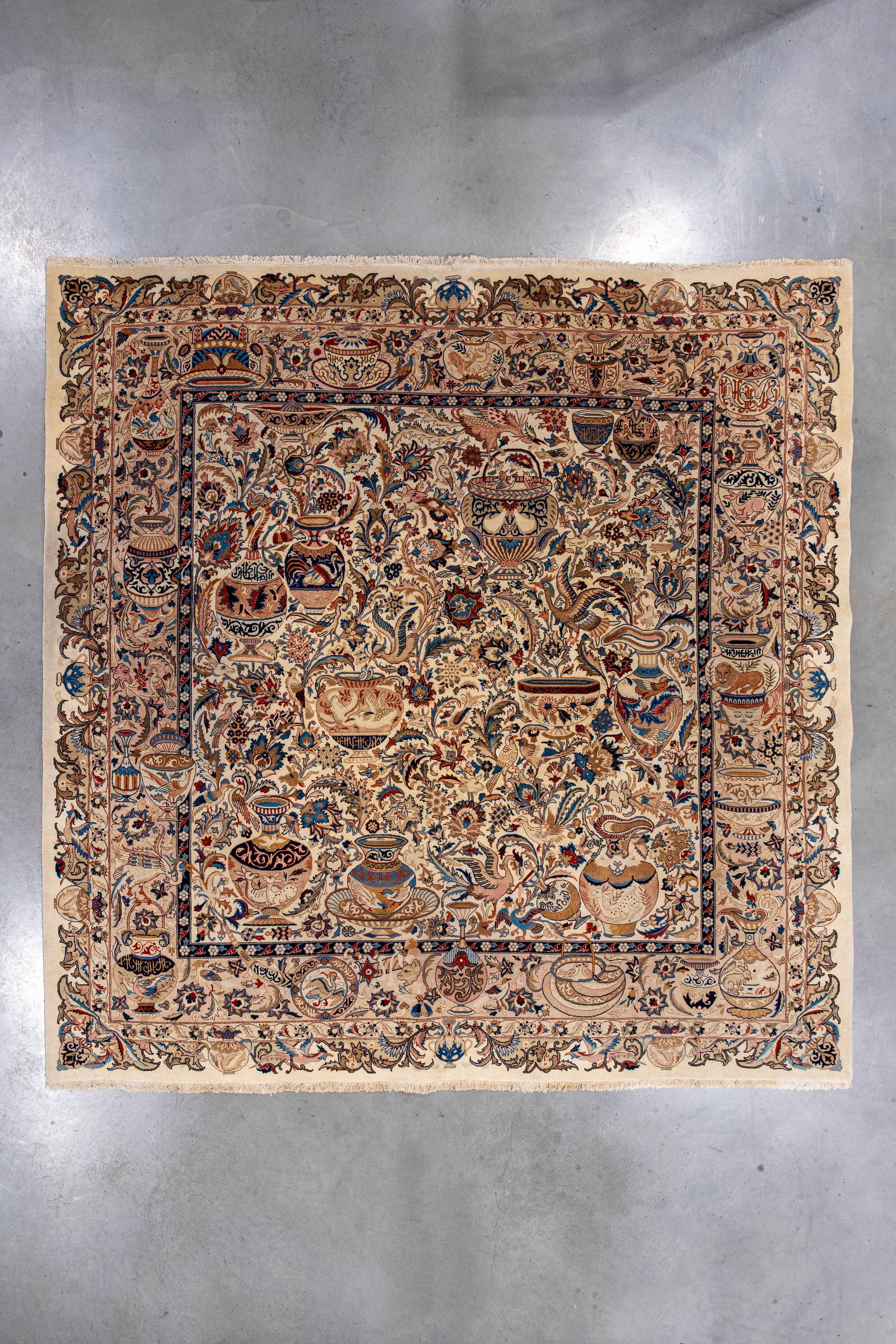 A large and square hand-knotted Persian Kashmar style wool rug: A large and square hand-knotted Persian Kashmar style wool rug decorated with an all-over pattern of vases, flowers and foliage, framed by a multi-border design. L: 300 - W: 295 cm