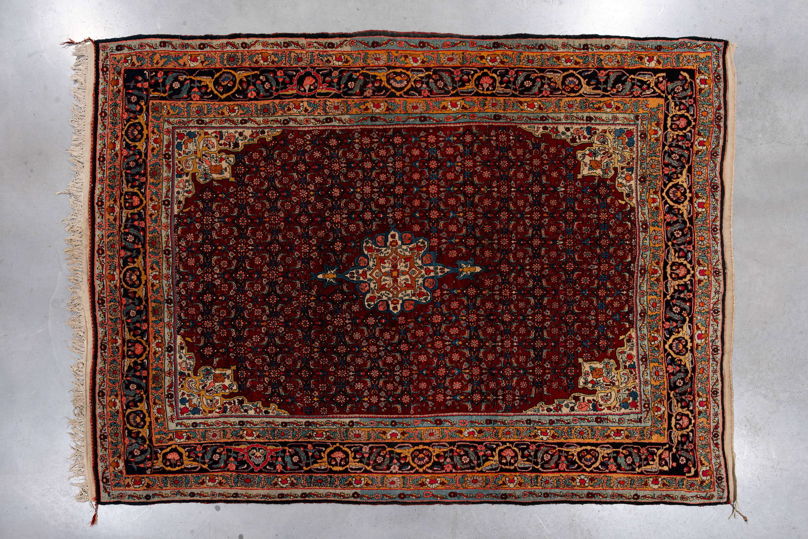A large Persian wool rug with a central medallion and floral decorations (1 of 9)