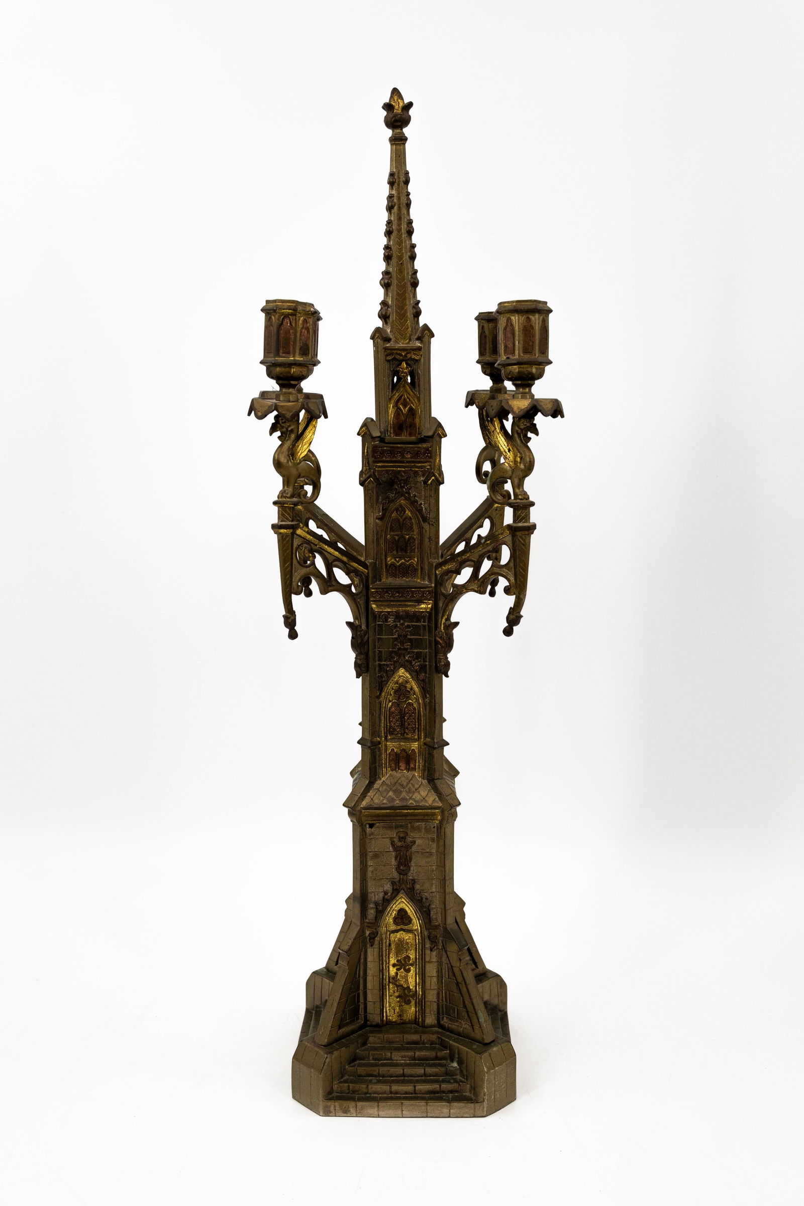 An antique gilt brass cathedral shaped gothic style decorated candelabra: An antique gilt brass cathedral shaped gothic style decorated candelabra. Circa 1900. H: 65 cm