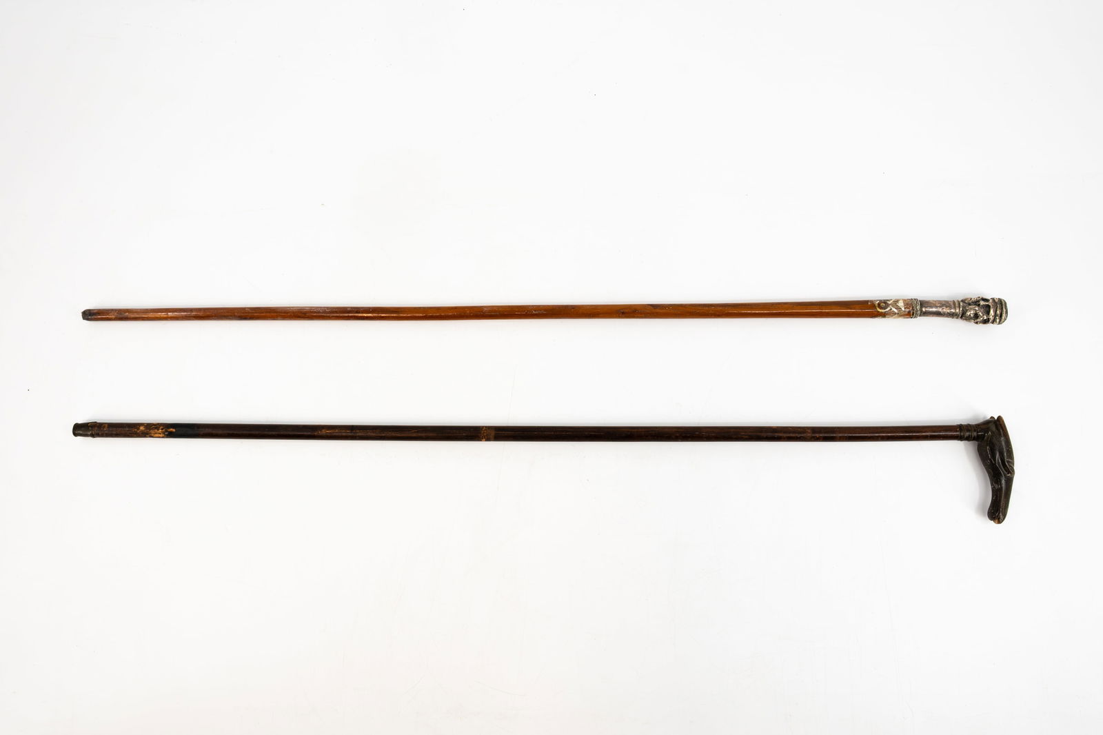 A lot of two antique variously decorated walking sticks.: A lot of two antique variously decorated walking sticks. One walking stick tested positive for silver with a Blue Tiger eye stone on top. One stick with a handle in horn. 19th/20th century. 