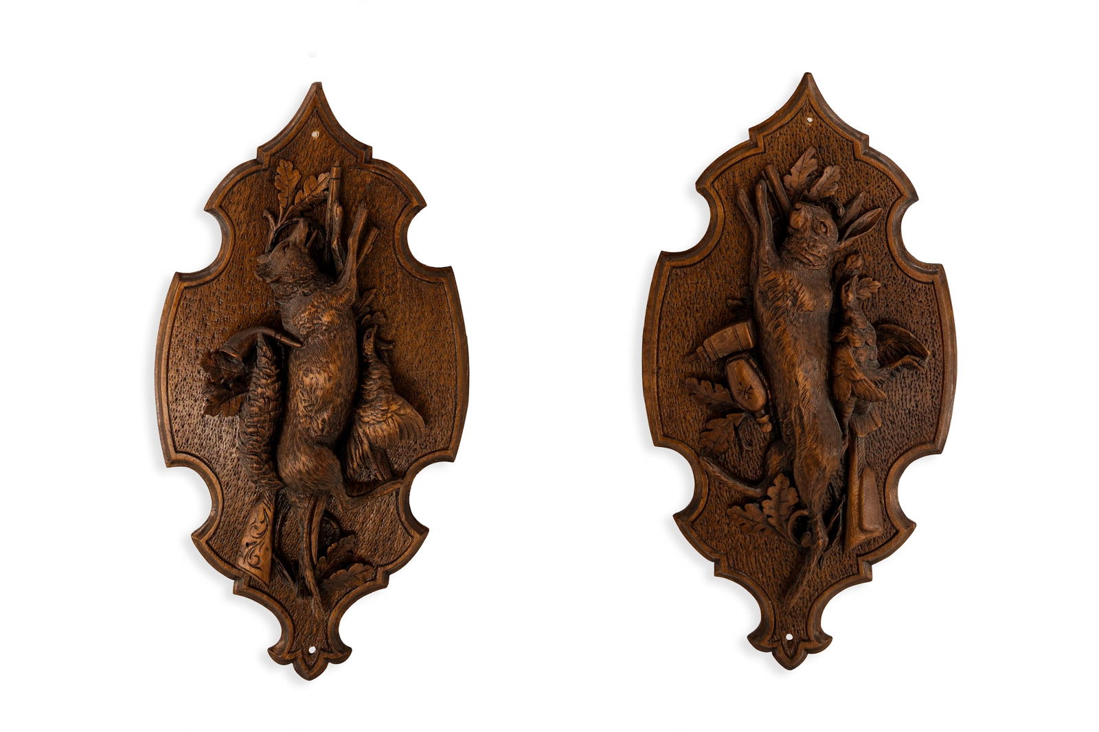 A pair of antique carved wooden black forest wall bas-relief sculptures of hunting trophies: A pair of antique carved wooden black forest wall bas-relief sculptures of hunting trophies. Circa 1900. H: 49 cm