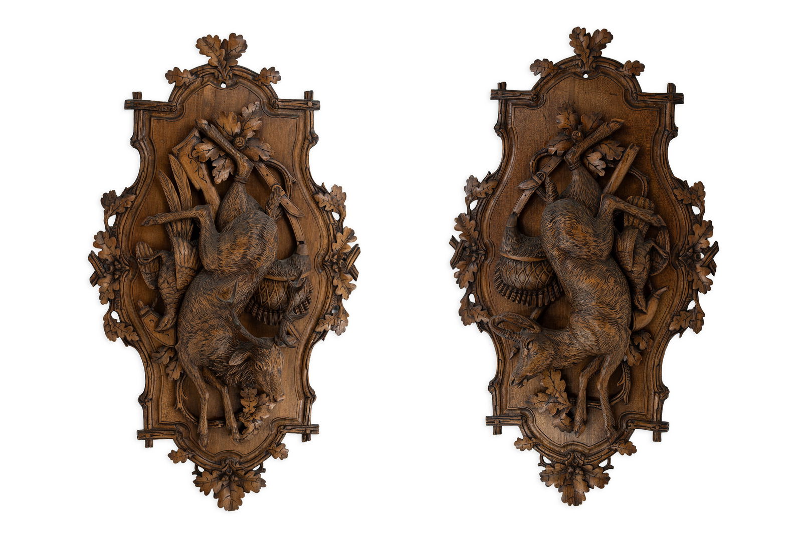 A pair of large antique carved wooden black forest wall bas-relief sculptures: A pair of large antique carved wooden black forest wall bas-relief sculptures representing hunting trophies. Circa 1900. H: 90 - W: 50 cm