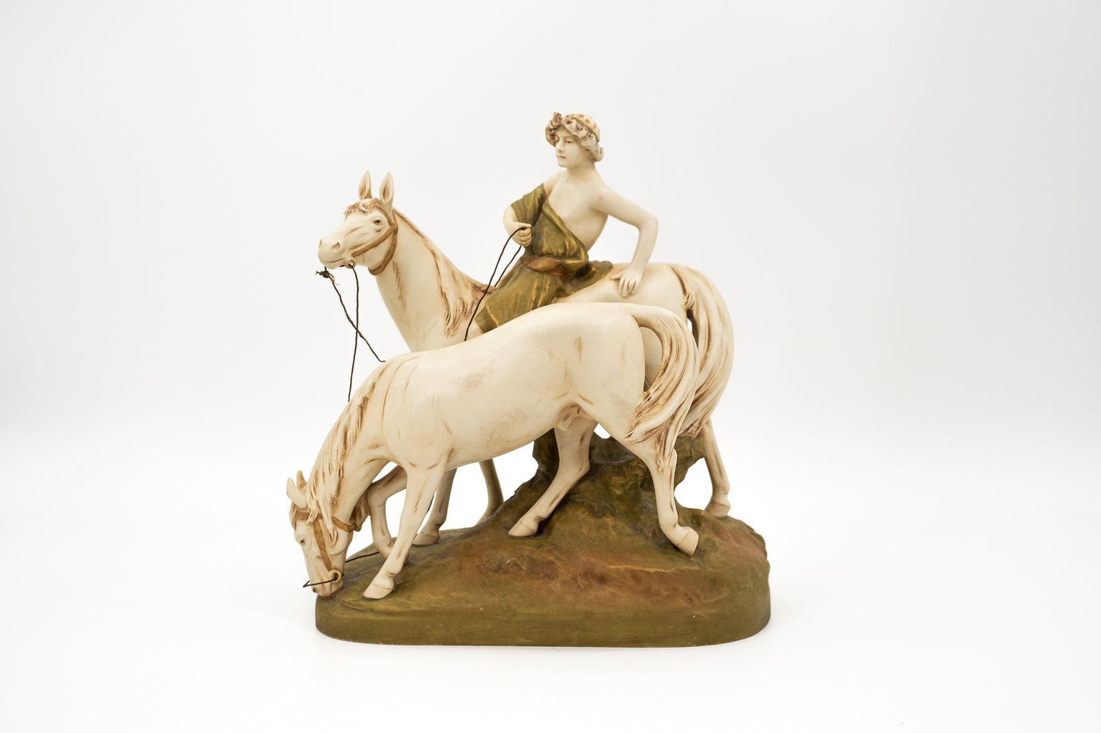 A Bohemian glazed porcelain Royal Dux figural group depicting two horses and a rider: A Bohemian glazed porcelain Royal Dux figural group depicting two horses and a rider. Marked and numbered. 19th/20th century. H: 33,5 cm