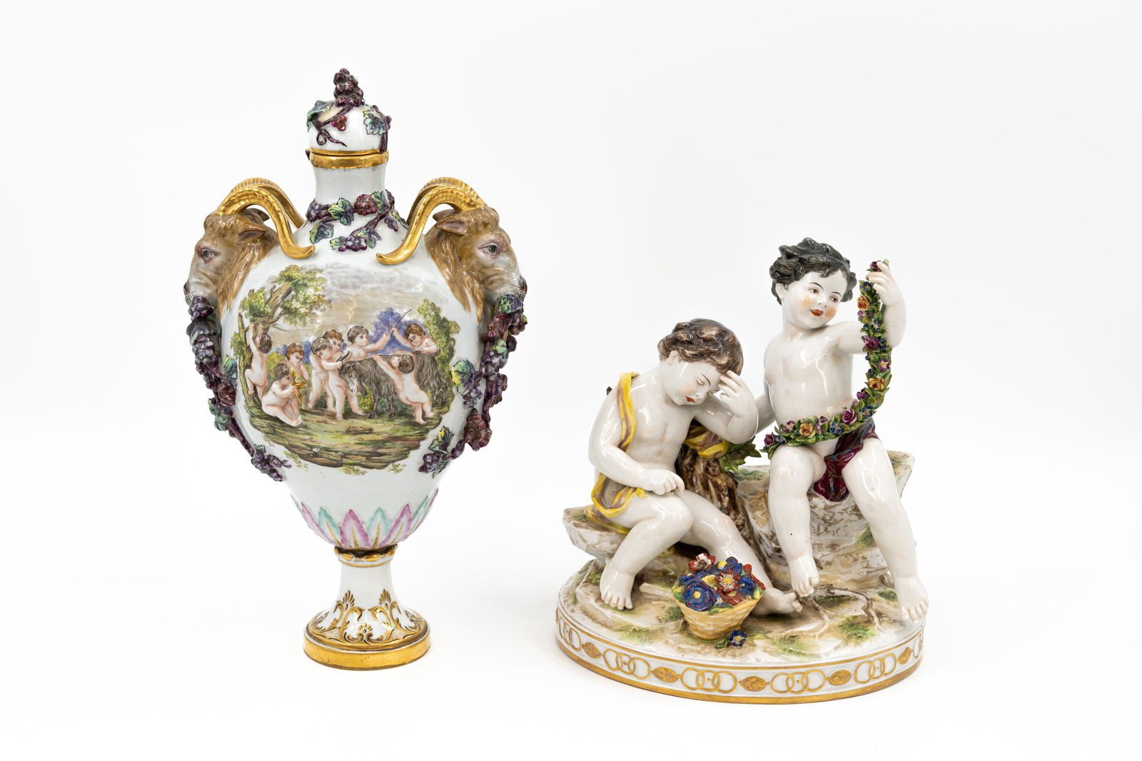 A composed lot of two Italian Napoli porcelain vase and figural group.: A composed lot of two Italian Napoli porcelain vase and figural group. Consisting of: one Rococo style covered vase with goat shaped handles and hand painted scene and one group with two large putti.
