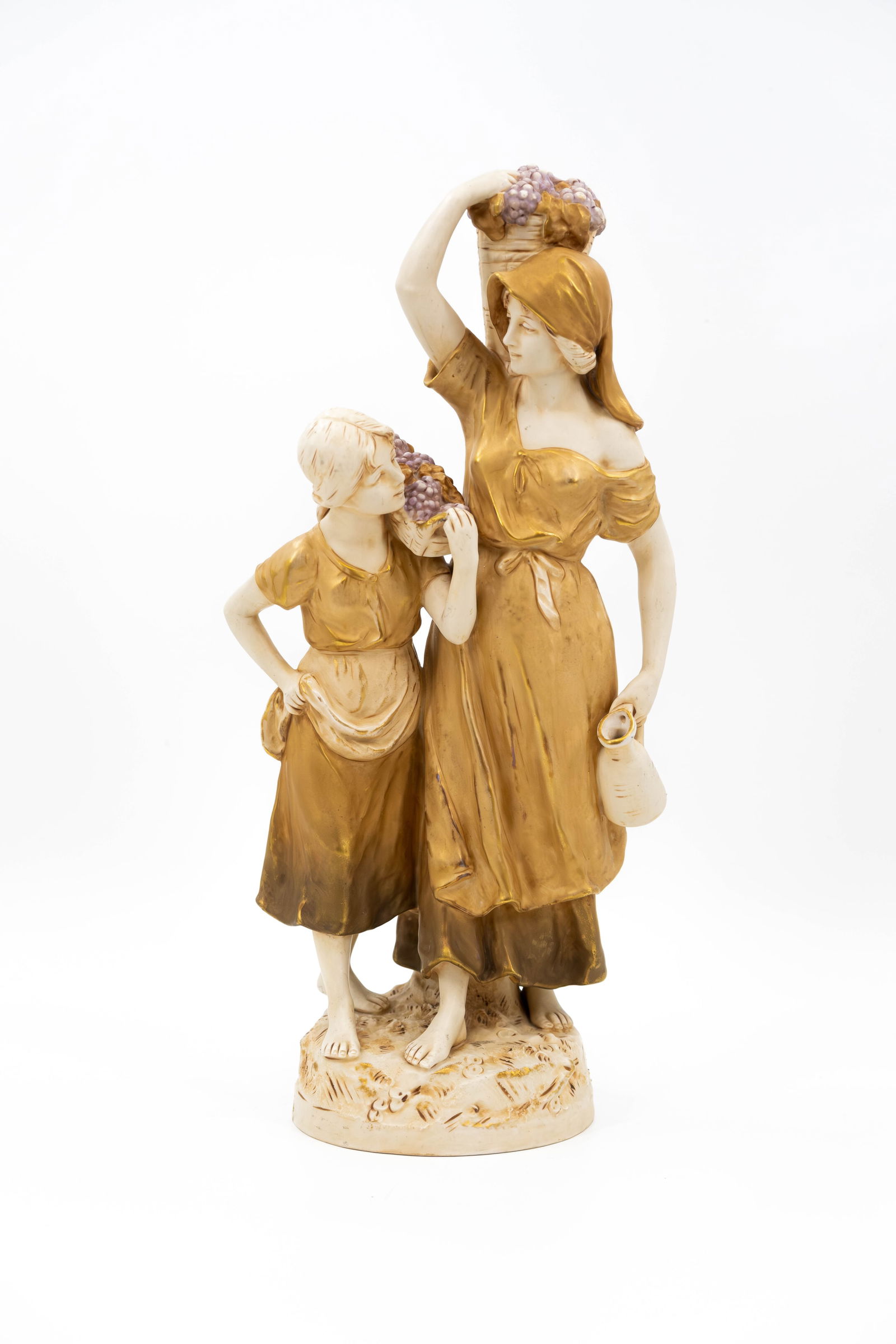 A Bohemian glazed porcelain Royal Dux figure of a lady and child as grape carriers: A Bohemian glazed porcelain Royal Dux figure of a lady and child as grape carriers. Marked and numbered. 19th/20th century. H: 47,5 cm
