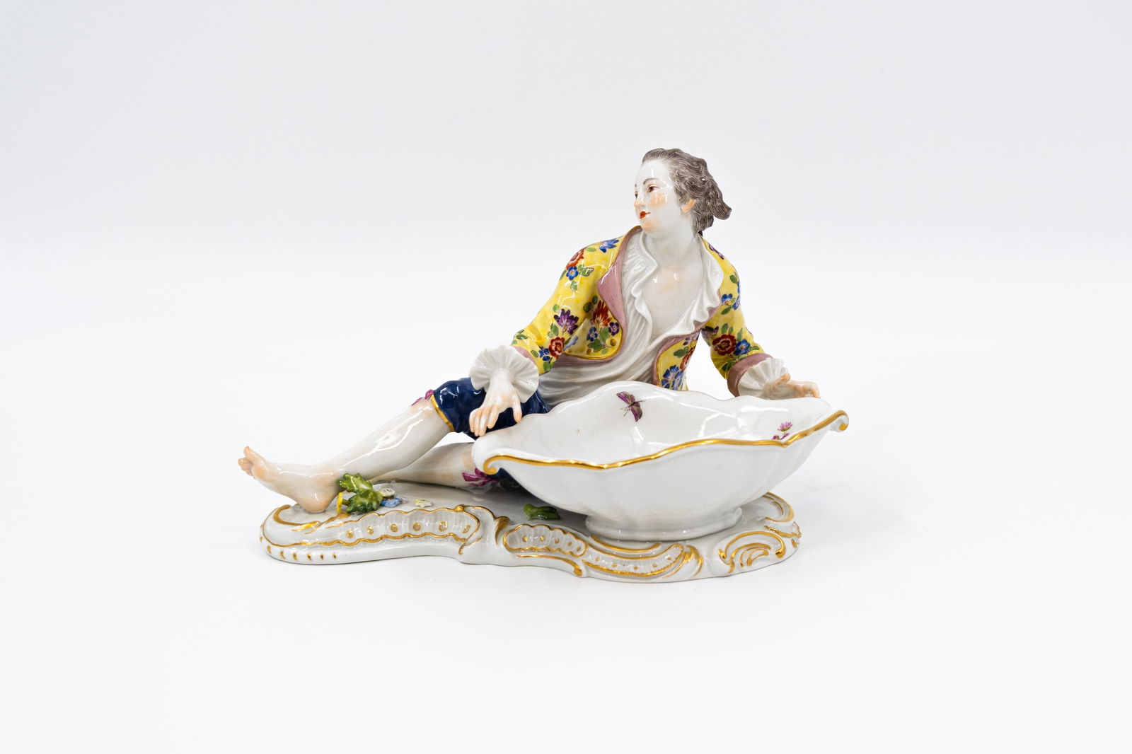 A German Meissen finely decorated porcelain figure of a man holding basket: A German Meissen finely decorated porcelain figure of a man holding basket. Blue underglaze crossed swords mark and numbered 369. 20th century. H: 12 - W: 17 cm