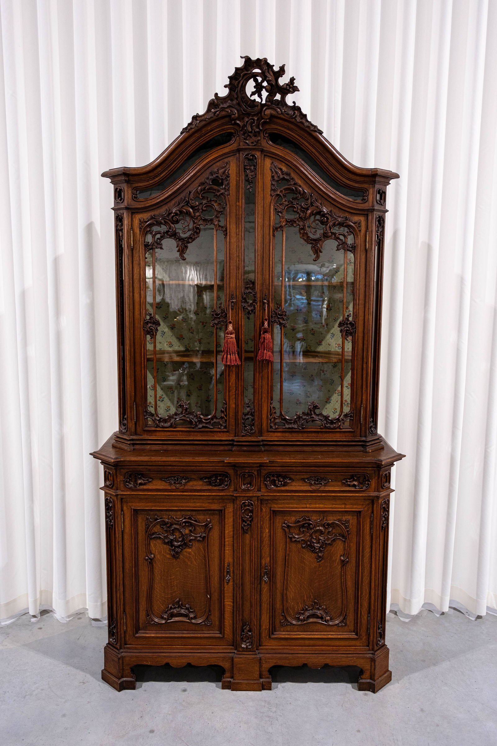 An antique Liége Louis XV-style carved oak wood decorated display cabinet: An antique Liége Louis XV-style carved oak wood decorated display cabinet with four doors and two drawers. 19th/20th century. H: 248 - W: 127 - D: 50 cm