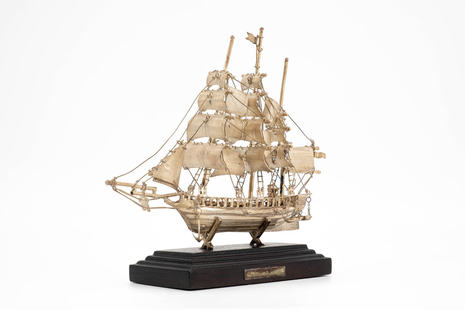 A sterling silver Mexican miniature ship model: A sterling silver Mexican miniature ship model, on wooden base. Marked 925. Mid-20th century. Weight: approx 100 grammes. (without base) H: 16 - W: 18 cm