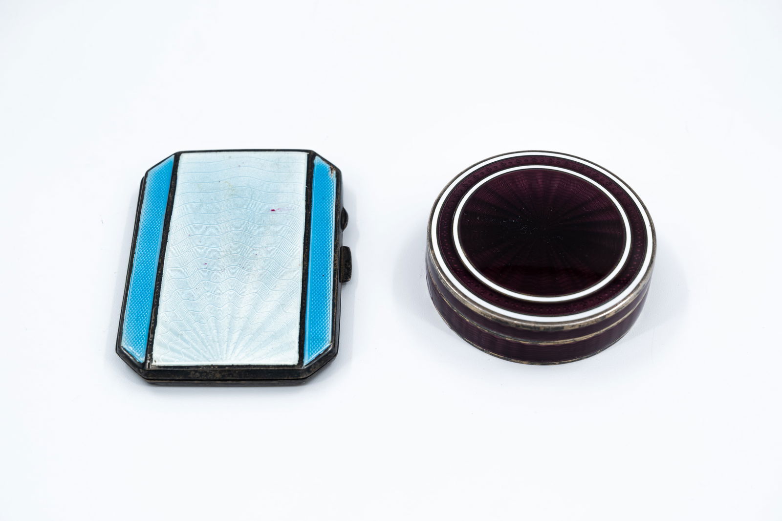 A lot of two silver and guilloché-enamel decorated cigarette and snuff boxes: A lot of two silver and guilloché-enamel decorated cigarette and snuff boxes. Hallmarks, circa 1900-1920s. W: 7 cm