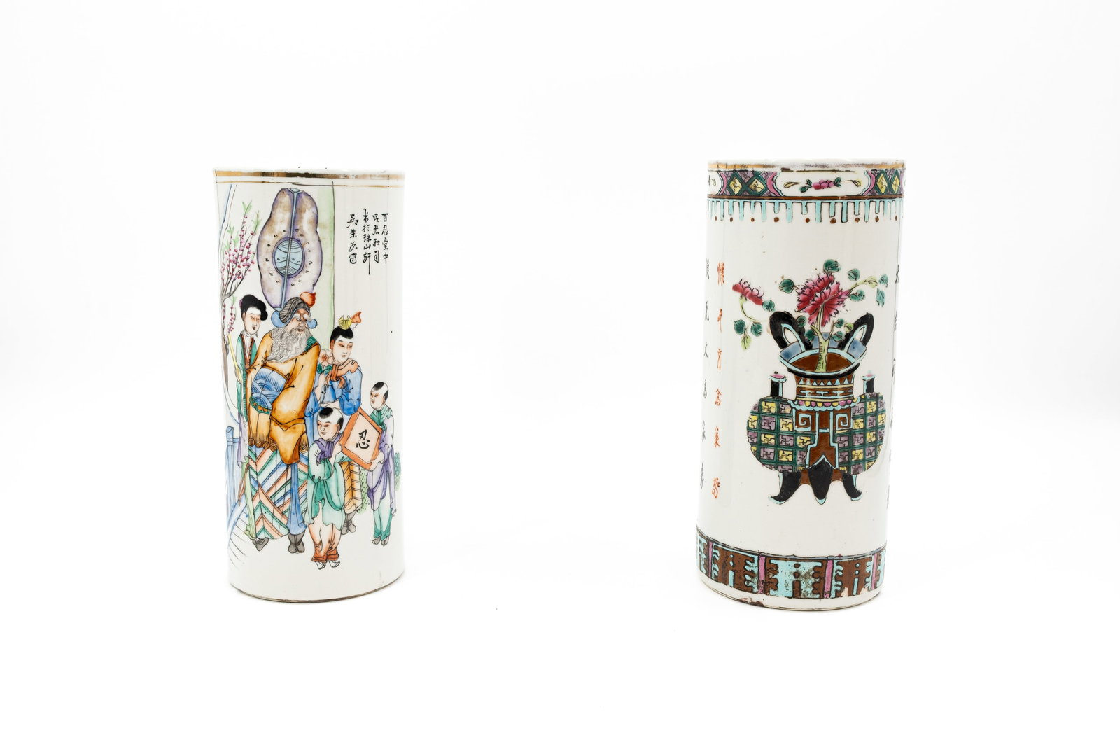 A composed lot of two Chinese Qianjiang and Famille rose decorated cylinder shaped porcelain hat: A composed lot of two Chinese Qianjiang and Famille rose decorated cylinder shaped porcelain hat vases with figural scene and valuables. 19th/20th century. Condition: the valuables decor has a hairlin