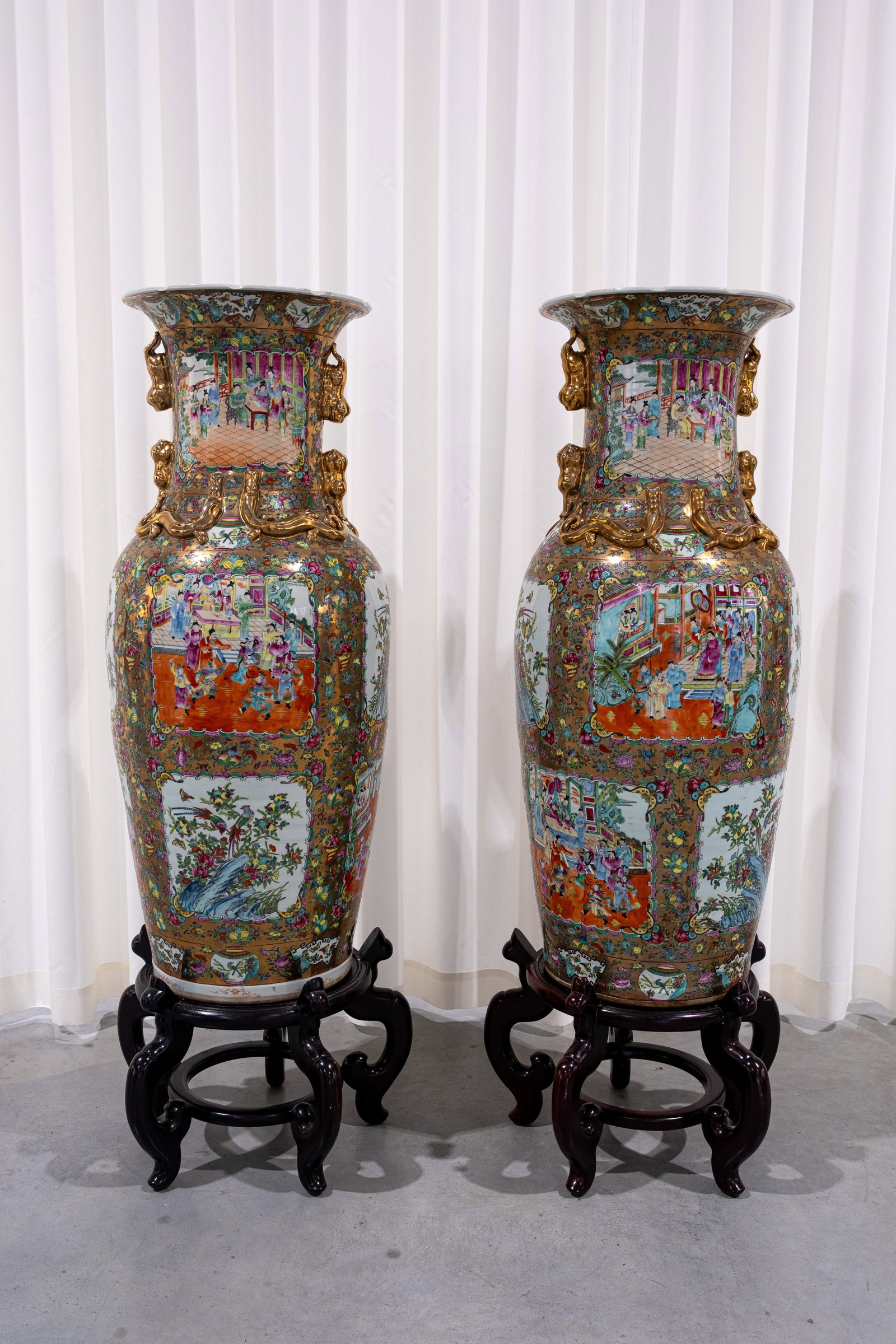 A lot of two large 20th-century Chinese Canton-style decorated porcelain vases: A lot of two large 20th-century Chinese Canton-style decorated porcelain vases, with temple and floral scenes. Both on wooden bases. Circa 1970s. H: 110 cm