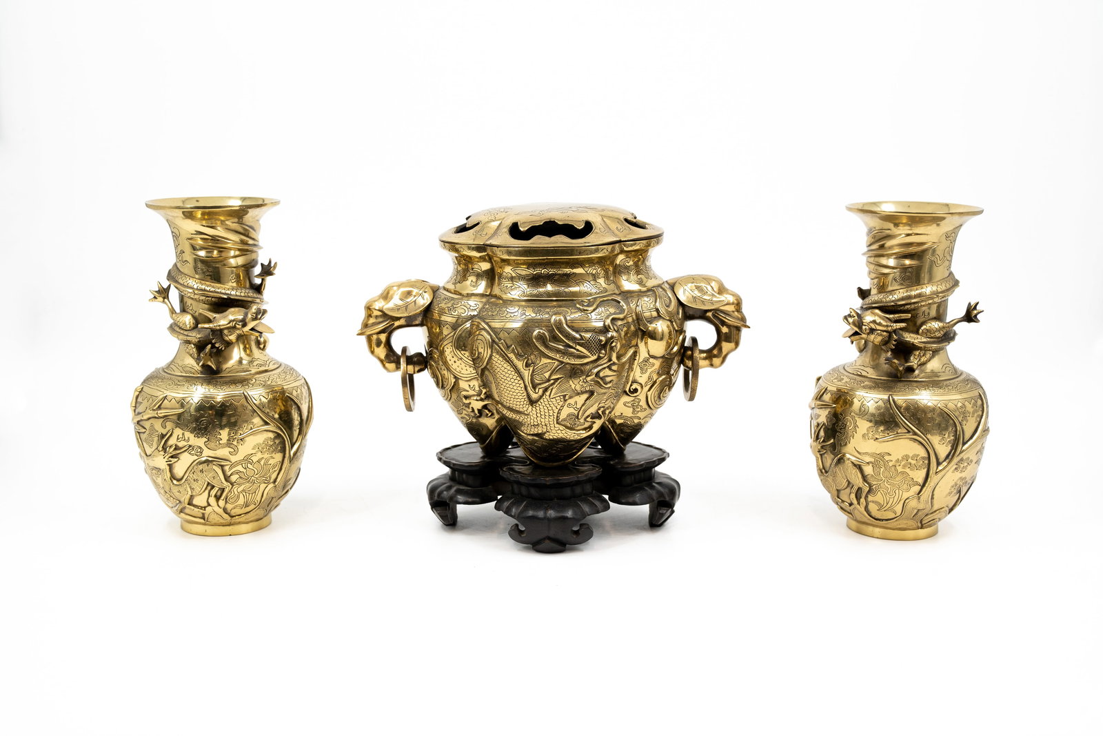 An antique and oriëntal pair of polished bronze vases, together with a matching incense burner: An antique and oriëntal pair of polished bronze vases, together with a matching incense burner with elephant shaped handles. The burner is footed on a wooden base. 19th/20th century. H: 19 - W: 29 cm