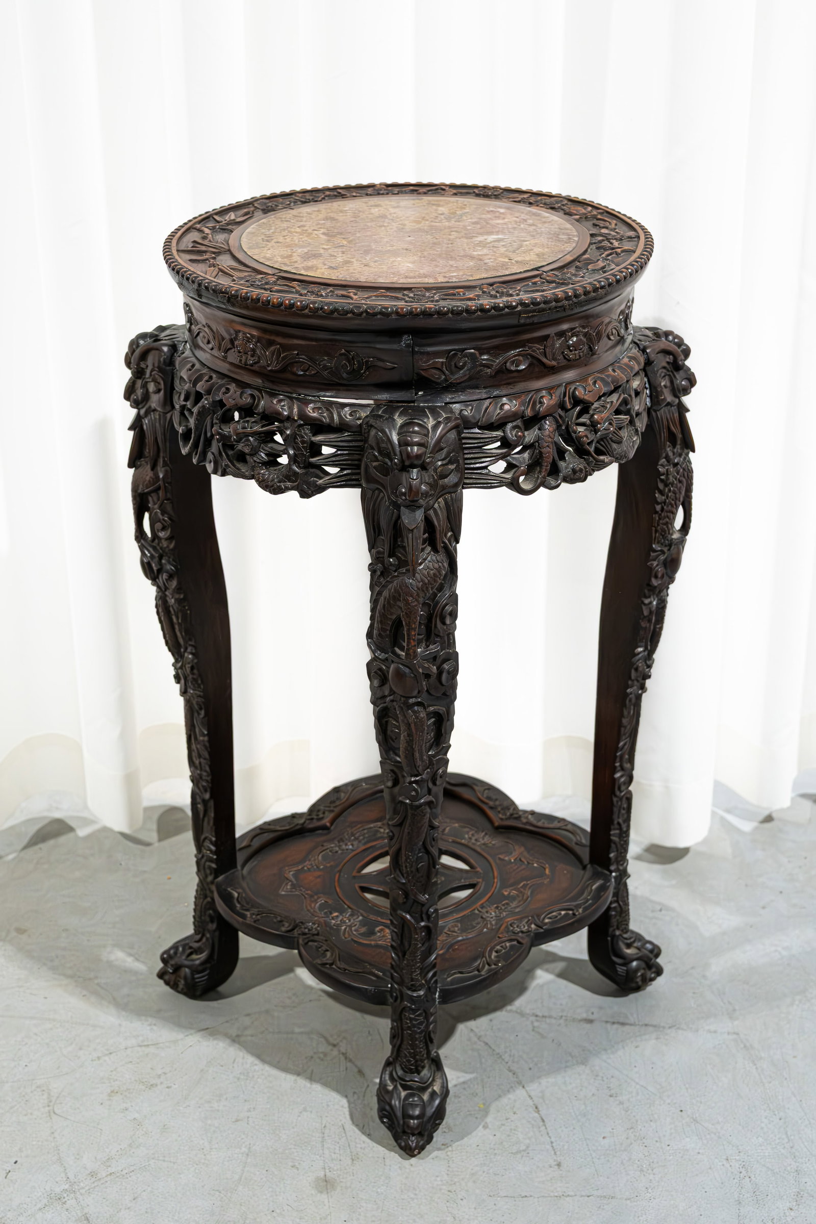 A large Chinese carved hardwood decorated pedestal with red marble top: A large Chinese carved hardwood decorated pedestal with red marble top. Late 19th century. H: 80 cm
