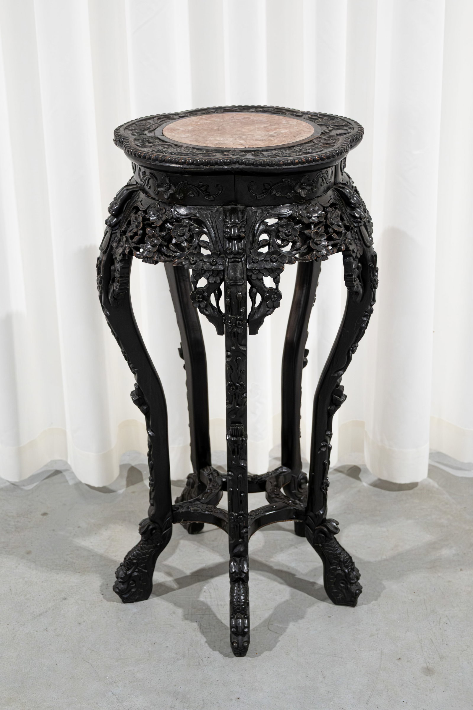 A Chinese carved hardwood pedestal with red marble tops and decorated with lion shaped heads: A Chinese carved hardwood pedestal with red marble tops and decorated with lion shaped heads. Late 19th century. H: 85 cm