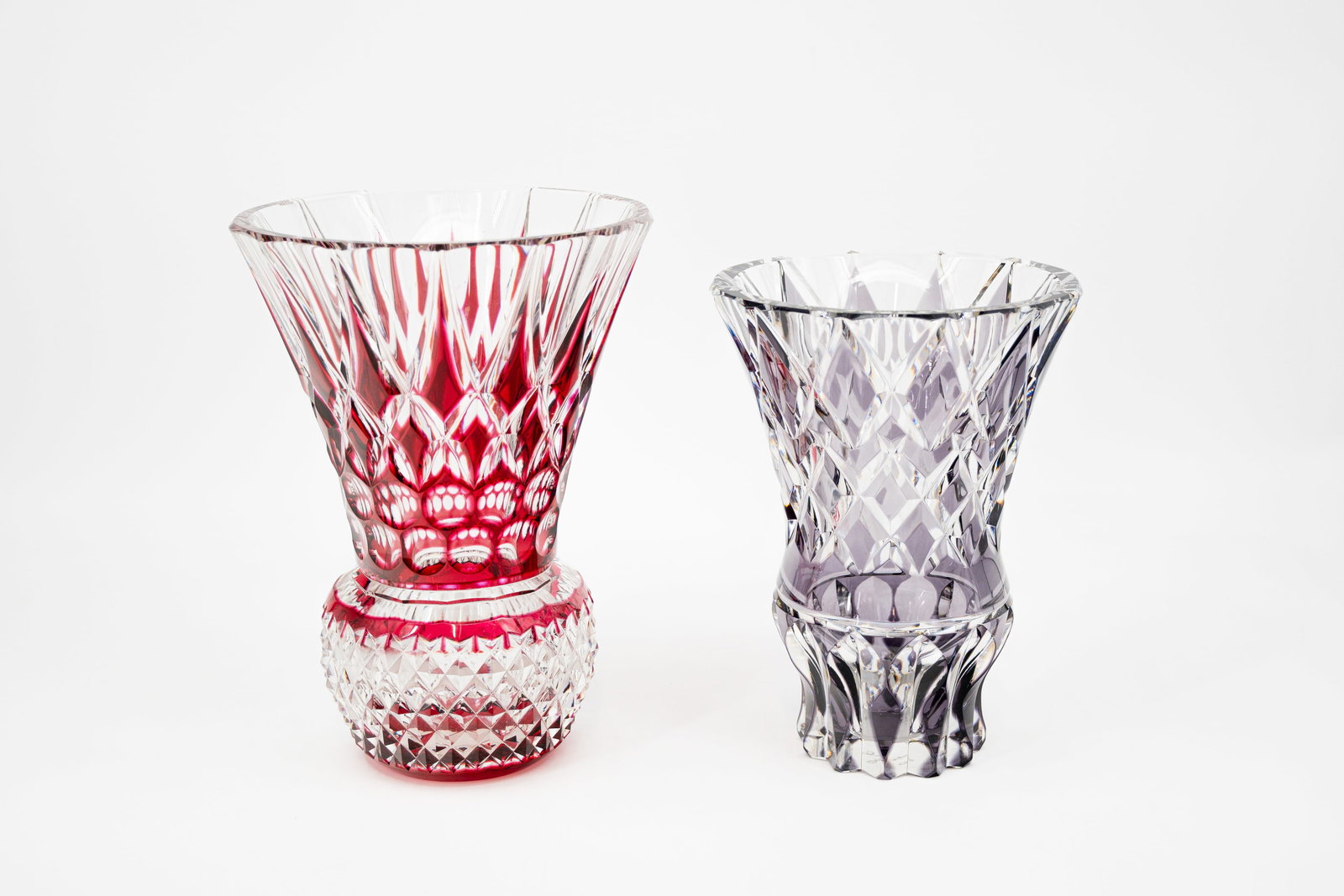 A lot of two large and Belgian Val Saint Lambert purple and red clear cut crystal vases: A lot of two large and Belgian Val Saint Lambert purple and red clear cut crystal vases. Both are signed and the purple colored vase is numbered 88/150. 20th century. H: 25 - 28 cm