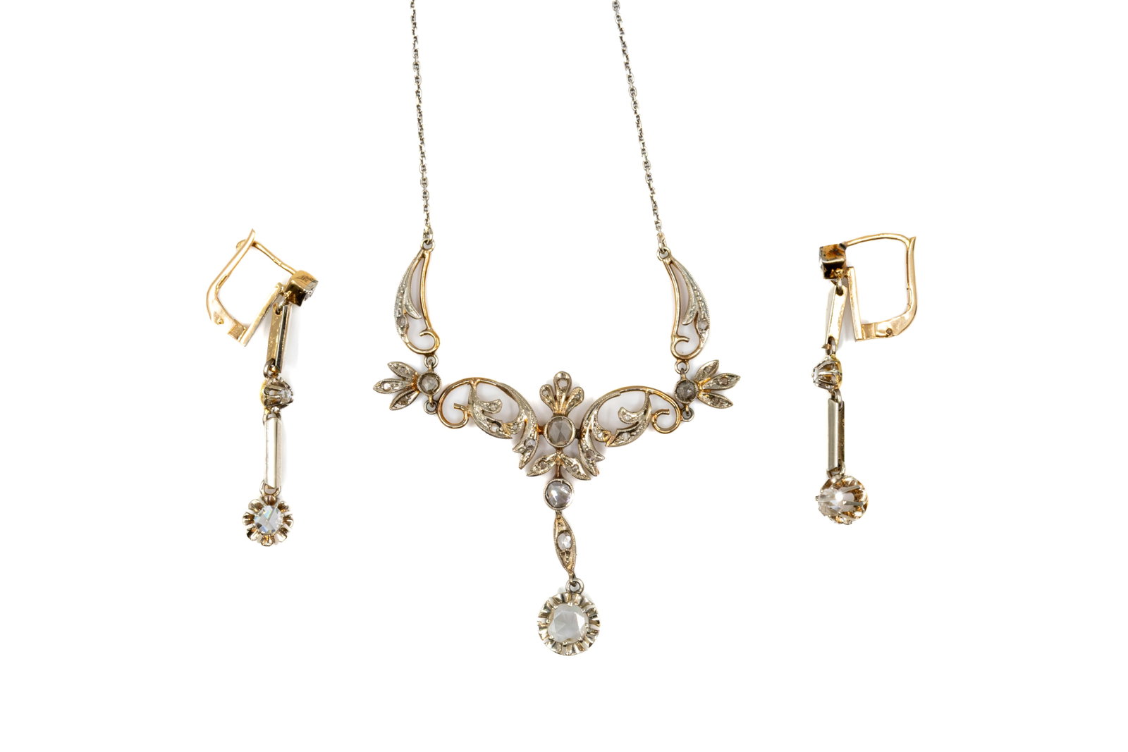 An antique art nouveau style 18k gold and silver jewelry set: An antique art nouveau style 18k gold and silver necklace with matching pendant earrings. The necklace with openwork foliate design, set with rose-cut diamonds and suspending a pendant drop, together 