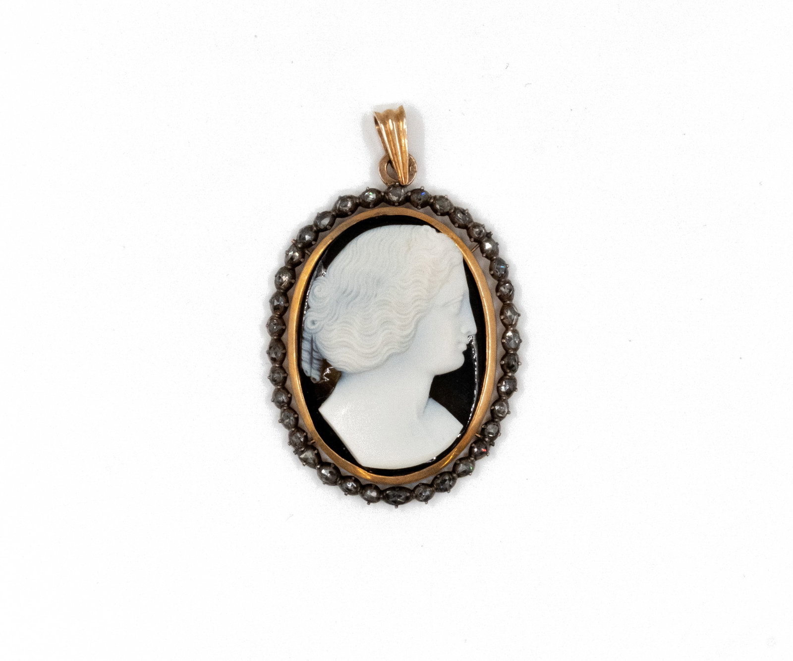A large gilt silver cameo pendant in agate bordered by rose-cut diamonds: A large gilt silver cameo pendant in agate bordered by rose-cut diamonds. An oval pendant with a carved female profile cameo, within a frame bordered by rose-cut diamonds. Total weight: 26,5g H: 5,8 -