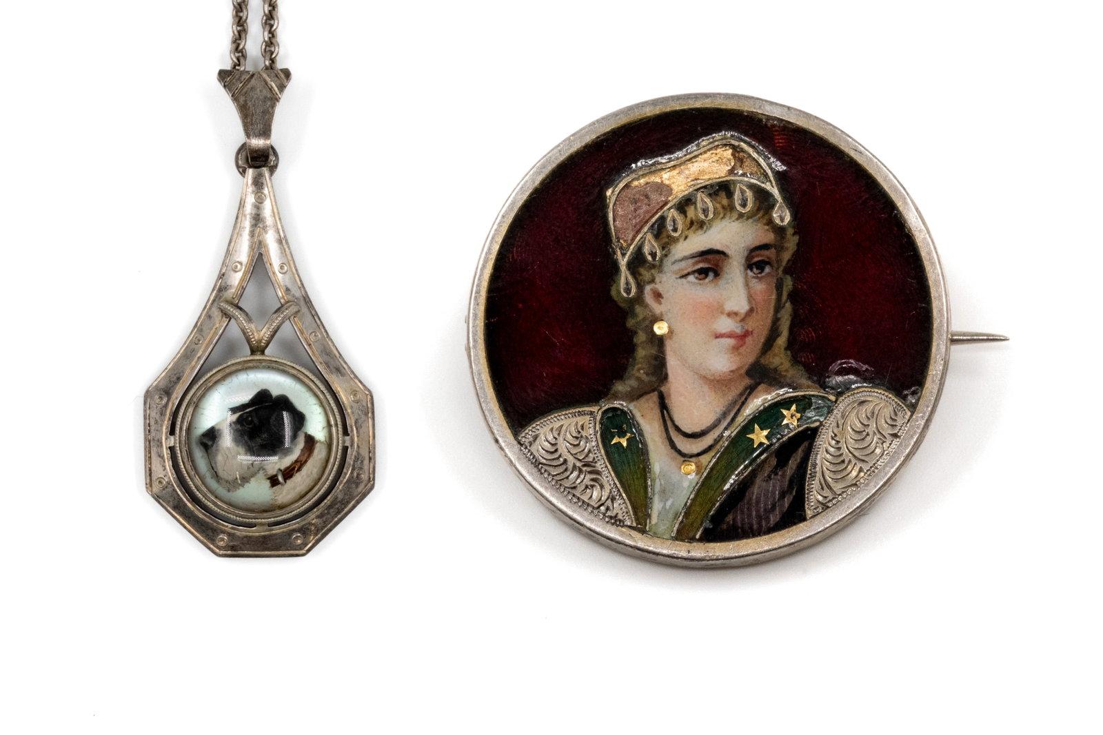 A lot of two silver portrait jewels: A lot of two silver portrait jewels. Comprising a round pendant with painted dog portrait under glass, in an openwork silver frame, together with a circular brooch with painted female portrait, marked