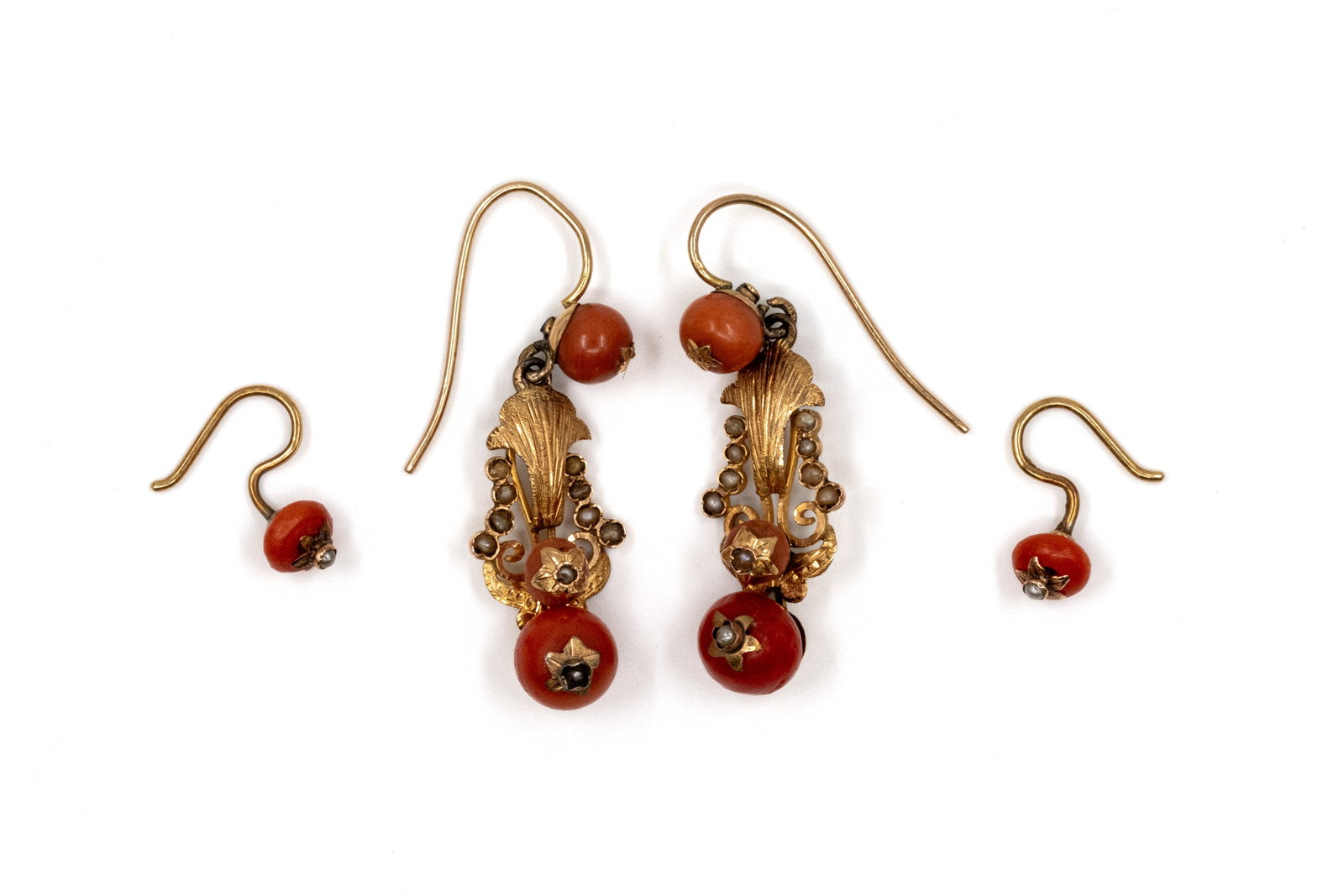 Two pairs of 18k gold and coral pendant earrings: Two pairs of 18k gold and coral pendant earrings. Two earring with openwork scroll and foliate design, all four are set with coral beads and small accent seed pearls, with gold hook fittings. Total we