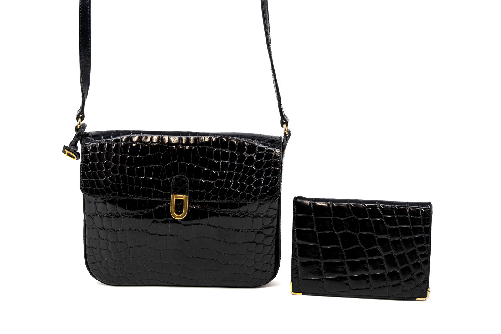 A composed lot of a vintage Delvaux cross-body bag in black crocodile leather together with a: A composed lot of a vintage Delvaux cross-body bag in black crocodile leather together with a matching wallet. Condition: the bag is in very good condition with no apparent signs of wear and tear, the